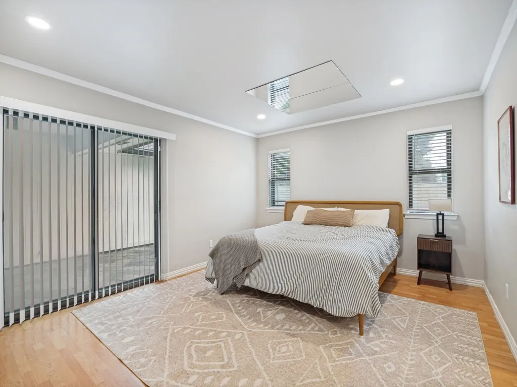 Spacious room featuring wood-finish flooring, recessed lighting, crown molding, and a mirrored ceiling accent