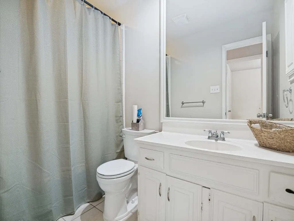 Bathroom featuring a white vanity with an integrated sink, polished chrome faucet, and ample under-sink storage