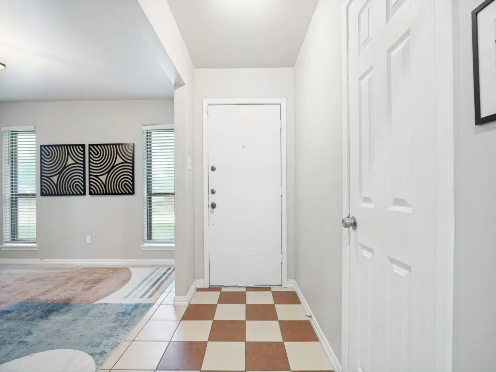Entryway featuring checkerboard tile flooring and a paneled interior door