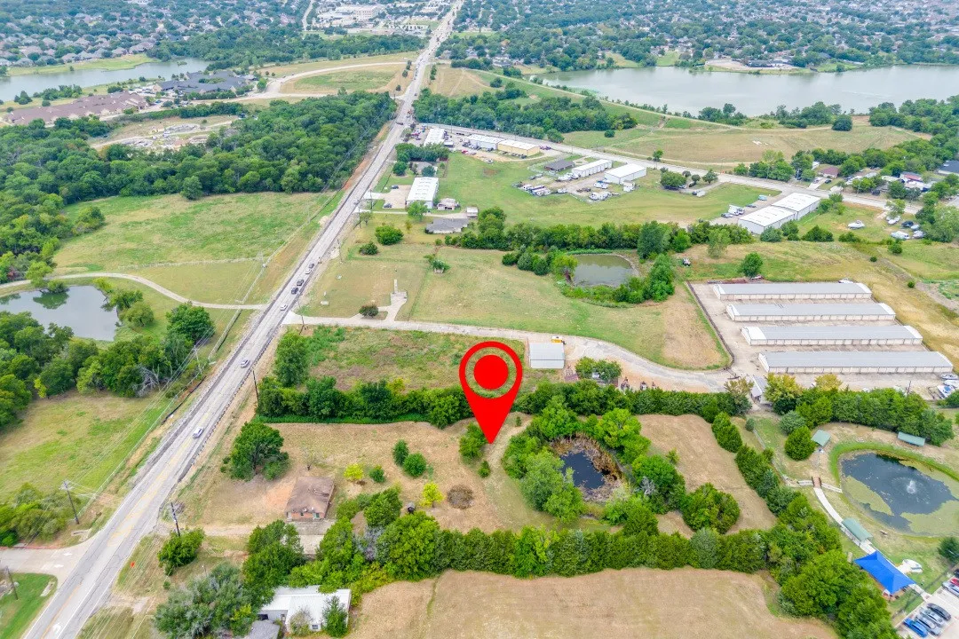 Aerial view of property and surrounding area featuring a large body of water and a tree filled landscape