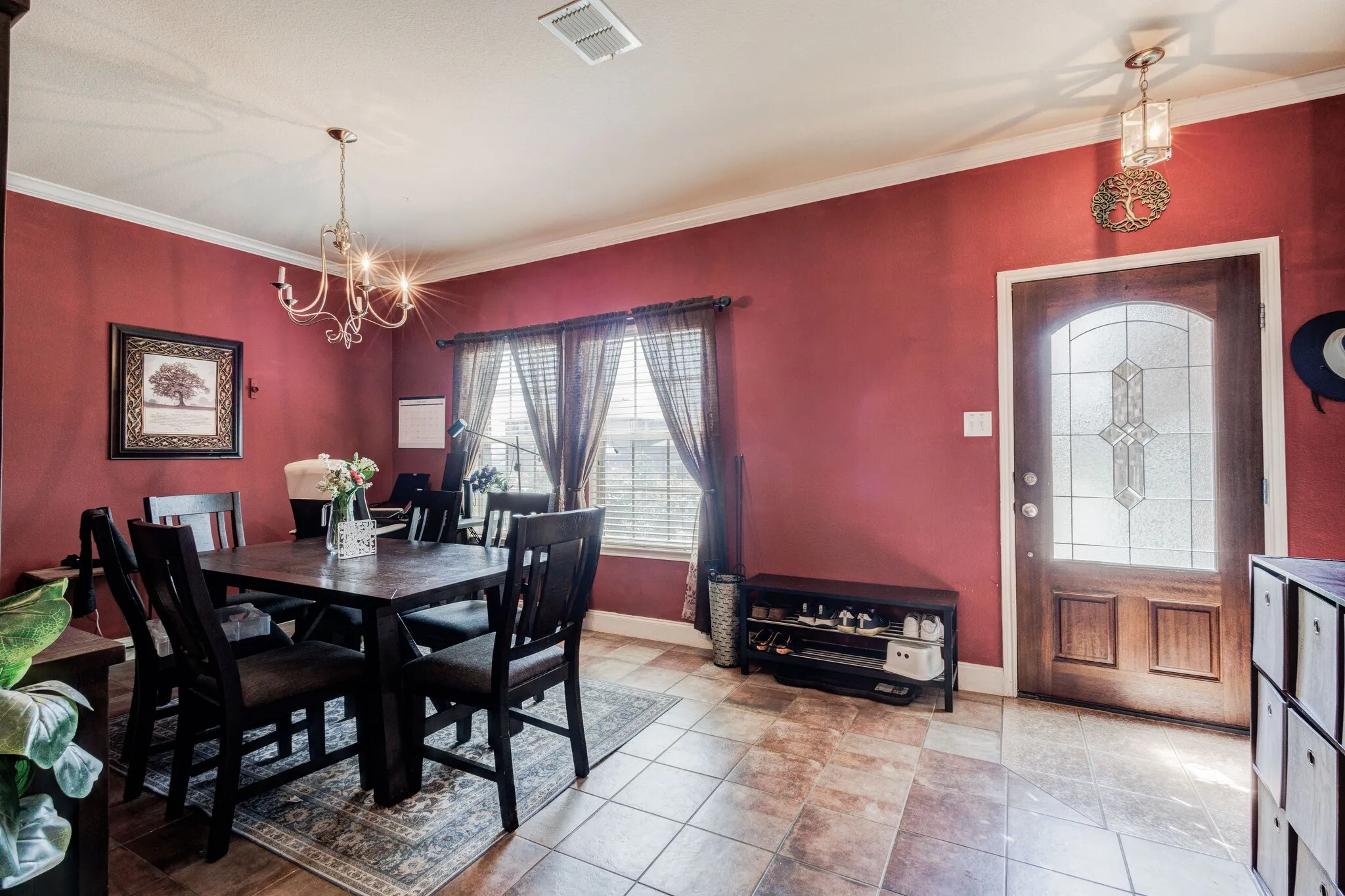 Formal dining area featuring tile flooring, crown molding, and a decorative chandelier