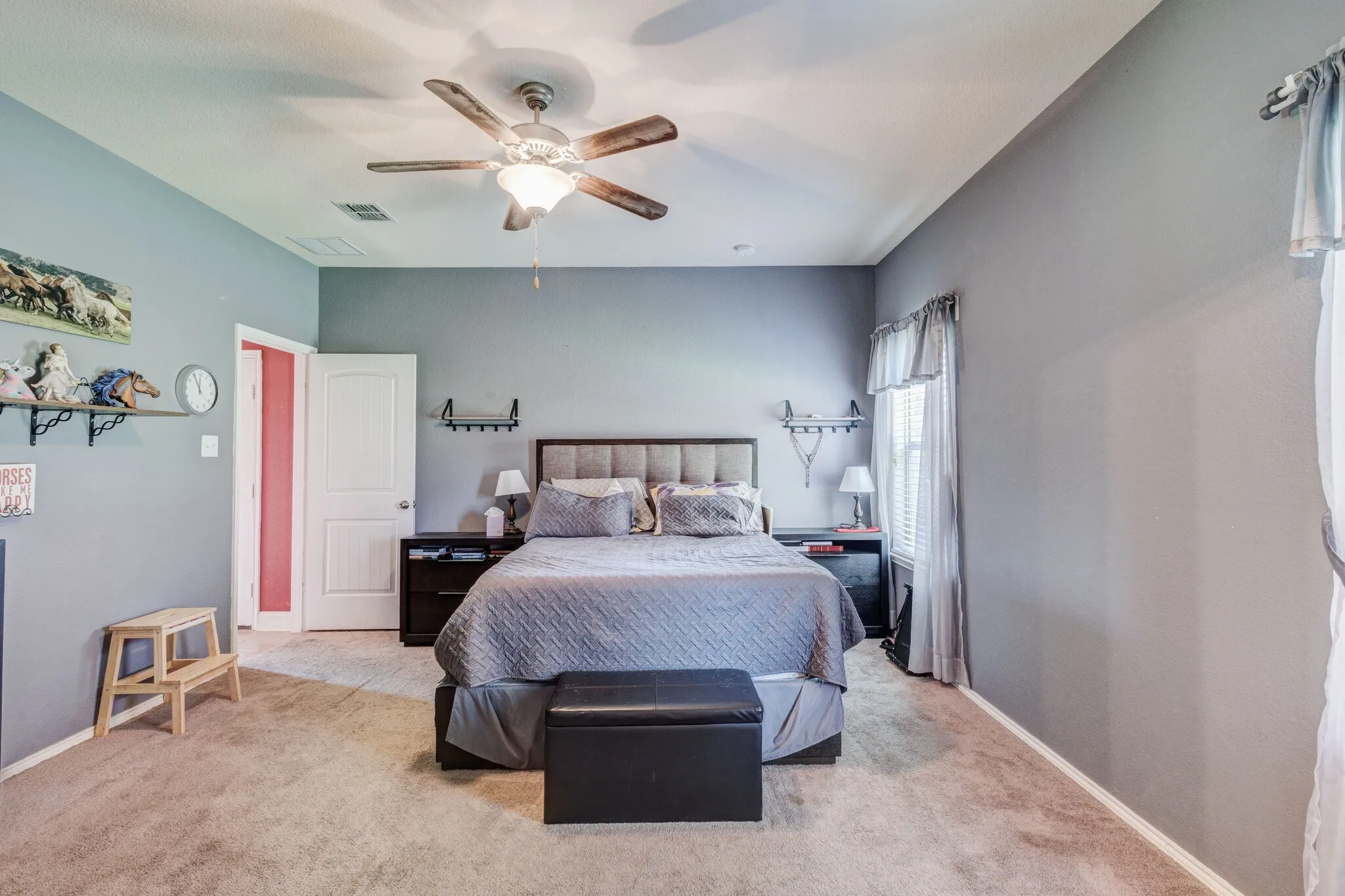 Carpeted bedroom featuring a vaulted ceiling with a ceiling fan, a window with blinds, and light gray walls