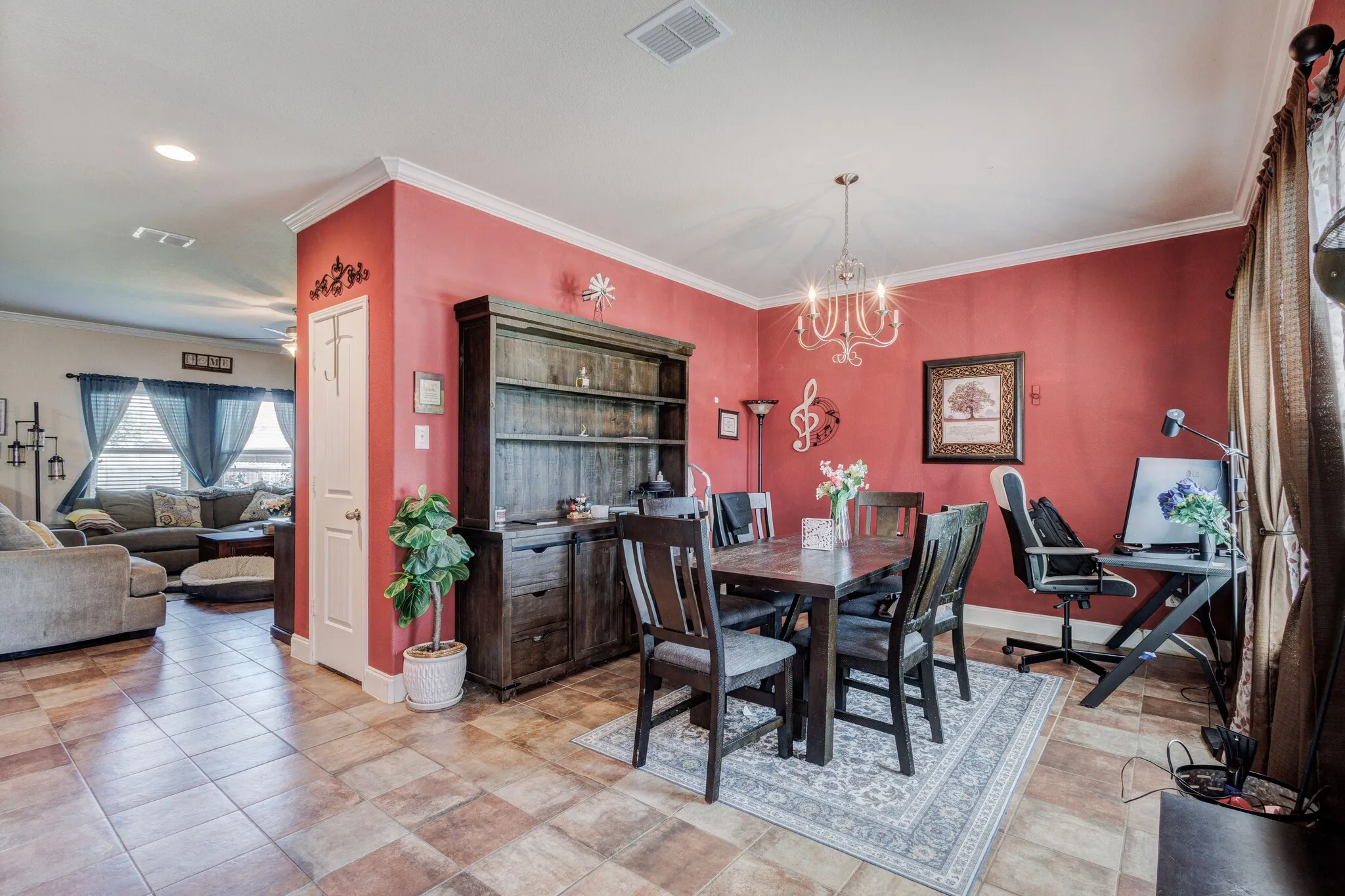 Dining space featuring a decorative chandelier, crown molding, and tiled flooring