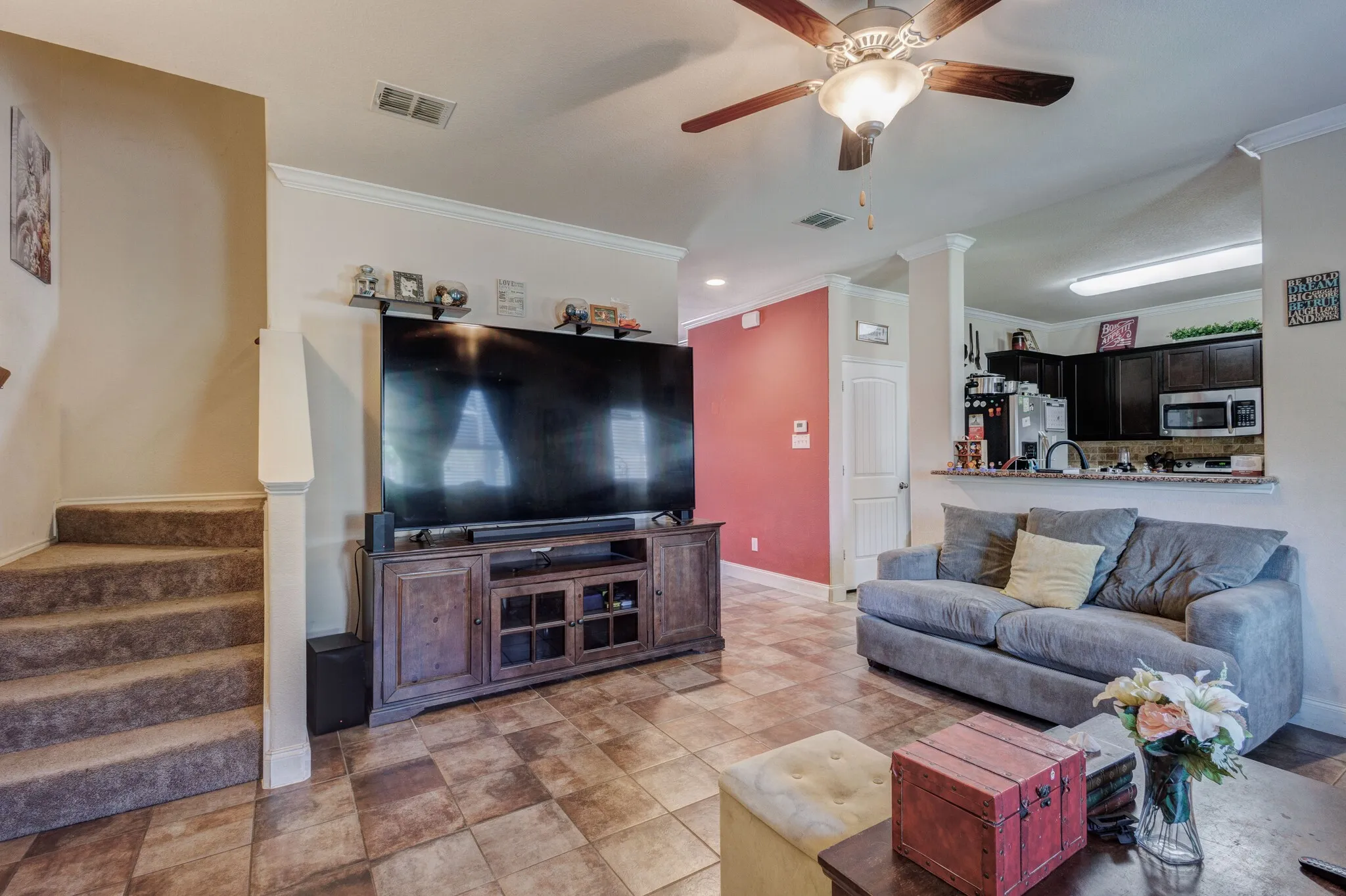 Spacious living area featuring tile flooring and crown molding
