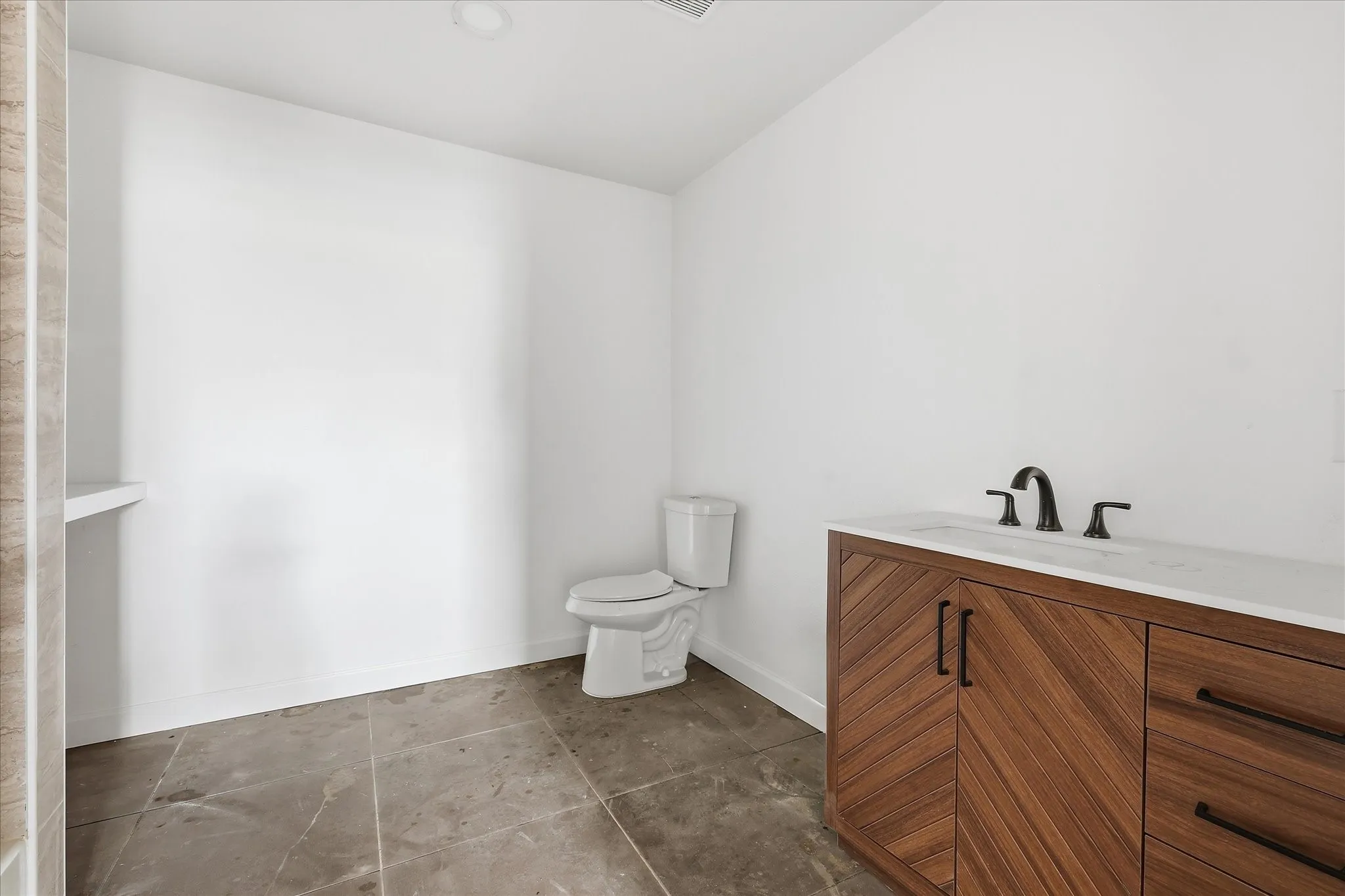 Contemporary bathroom vanity featuring a white countertop, matte black fixtures, and rich wood-finish cabinetry