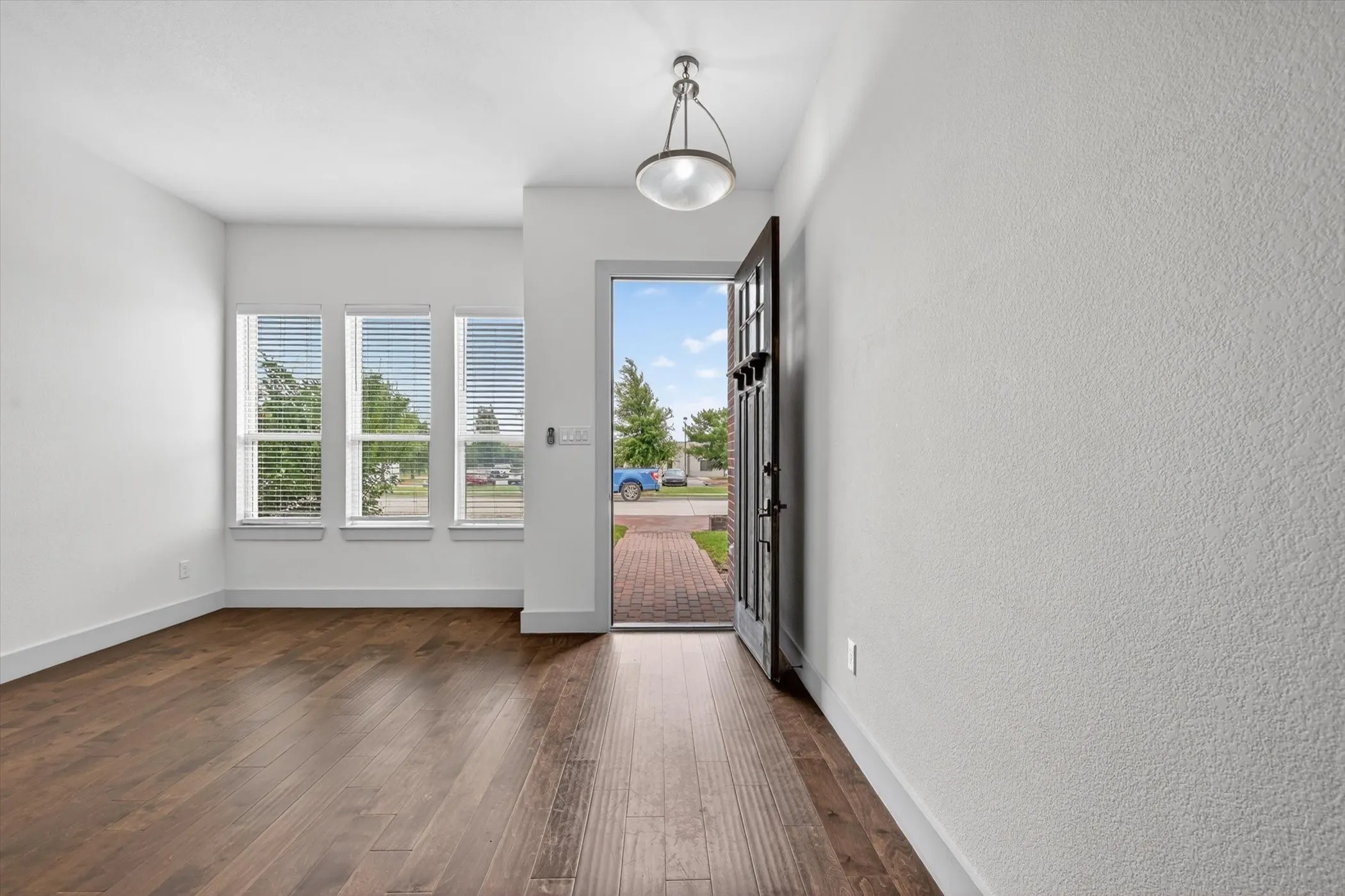 Bright entryway featuring wood-finish flooring and a contemporary pendant light fixture