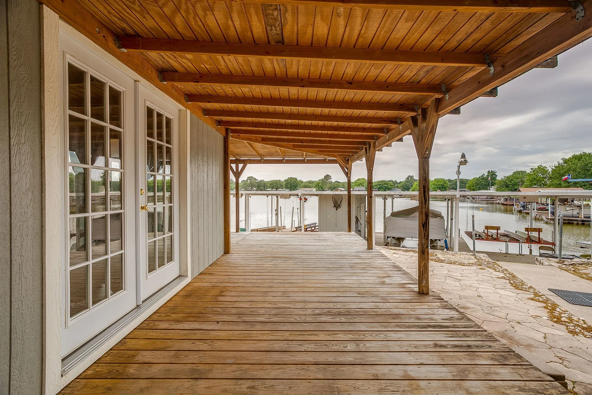 Expansive covered porch featuring wood-finish flooring and a natural wood ceiling