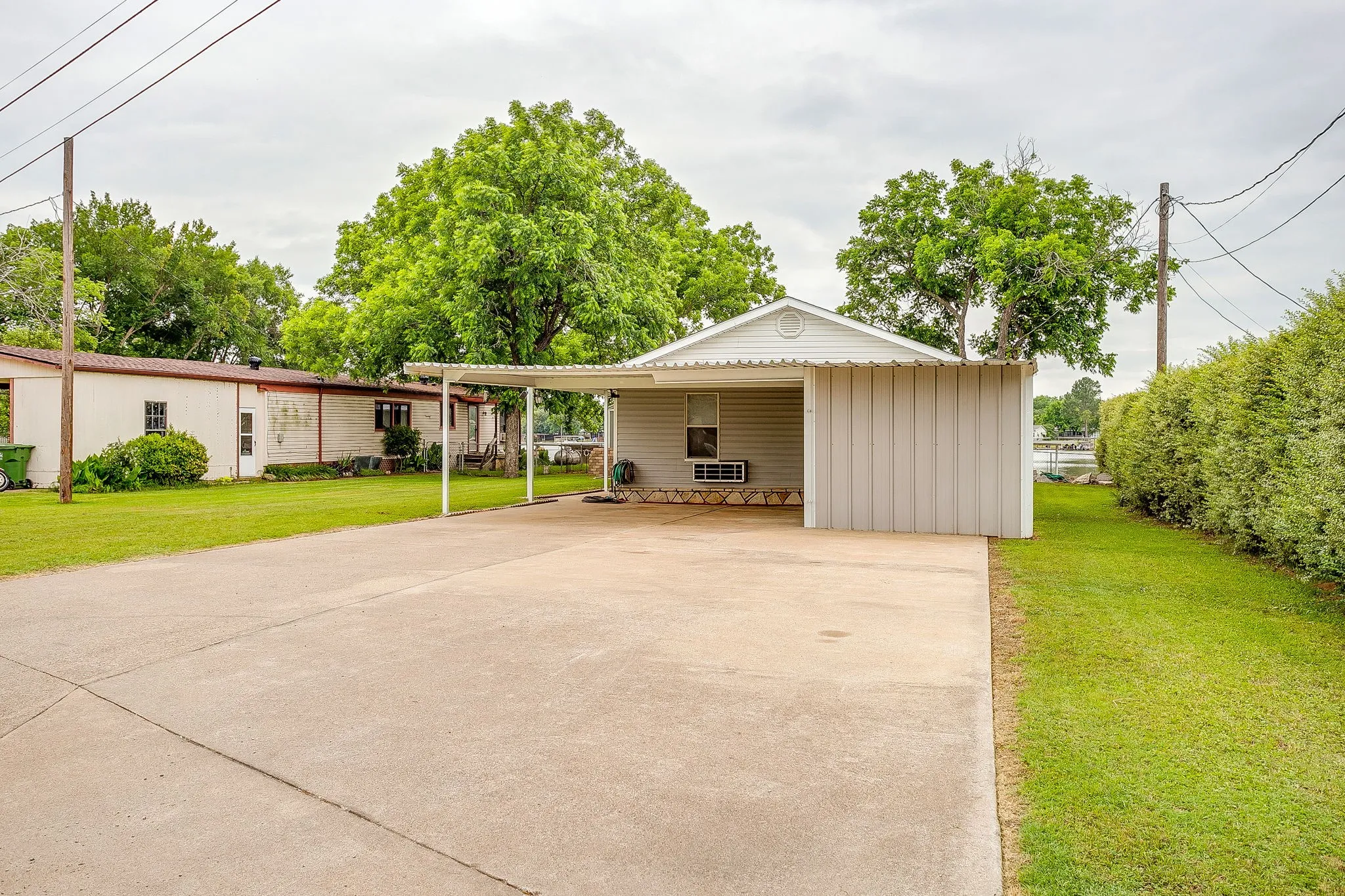 Concrete driveway extending to a covered carport