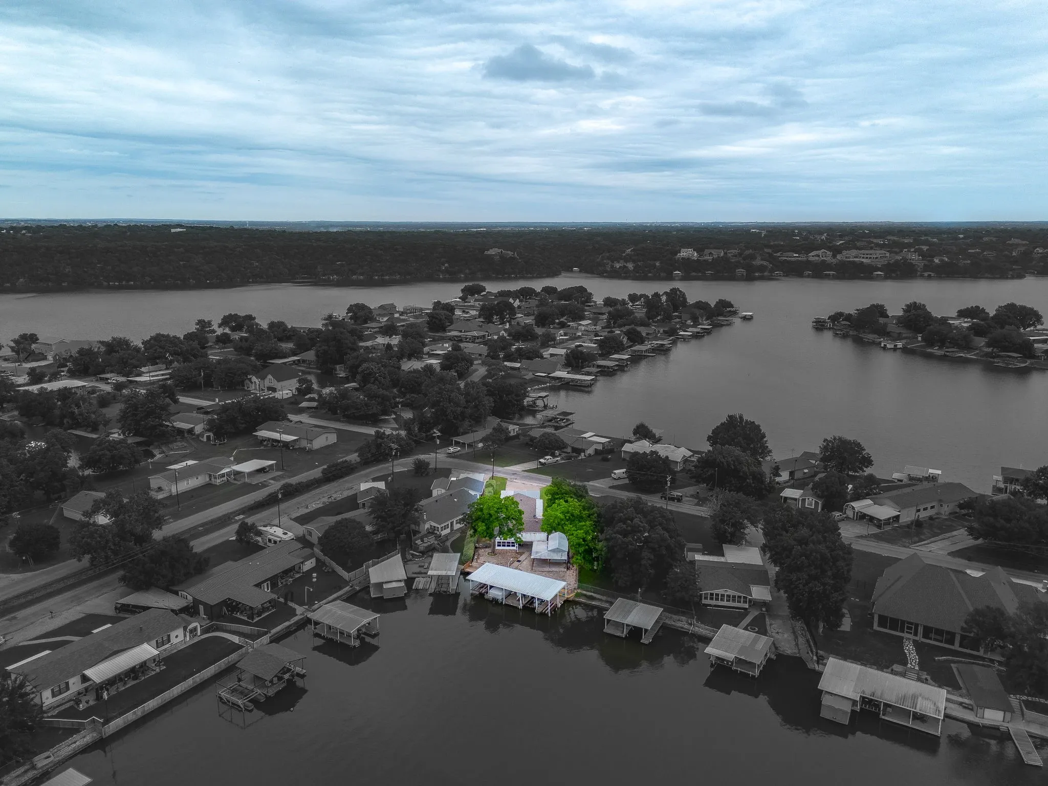 Waterfront property featuring a private boat dock, mature trees, and a spacious lot