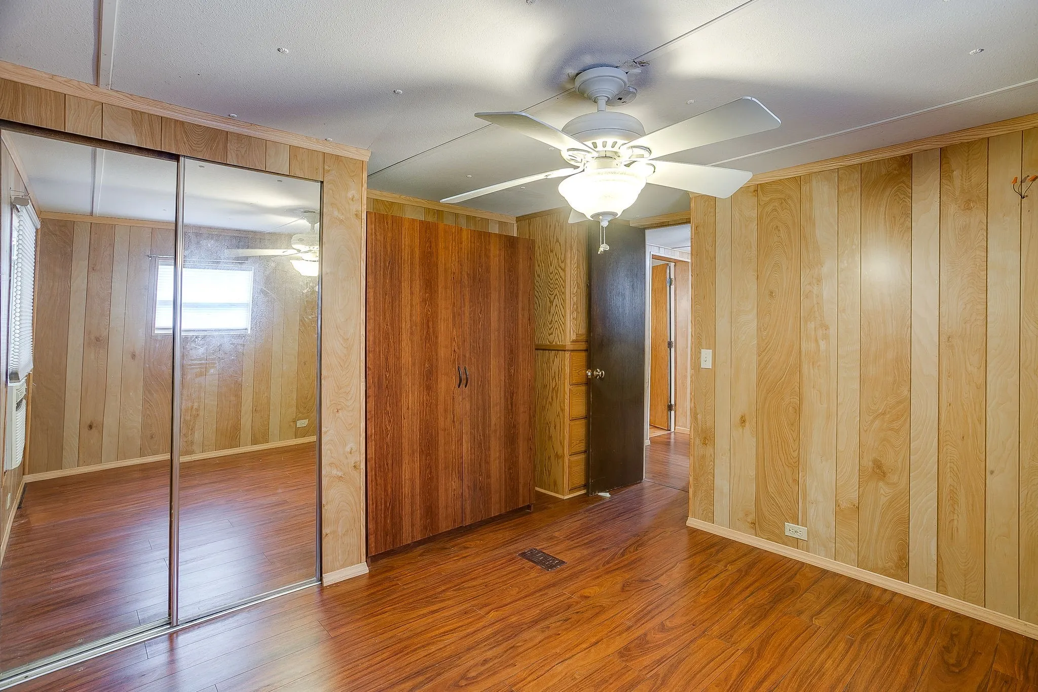Warm wood-finish flooring complements the natural tone wood paneling throughout the space