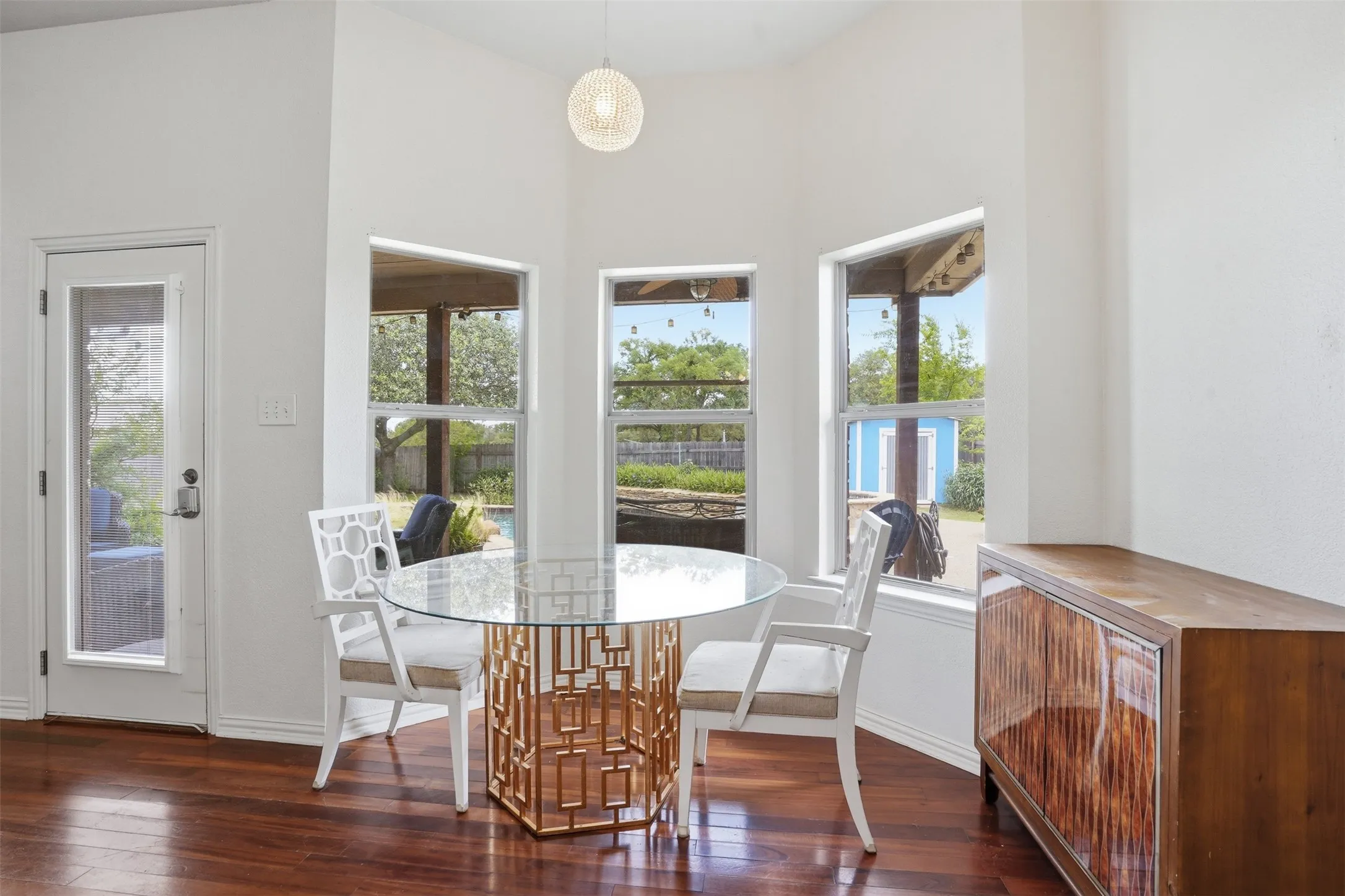 Dining nook with high ceilings, three large windows, wood-finish flooring, and a glass-paneled exterior​​‌​​​​‌​​‌‌​‌‌​​​‌‌​‌​‌​‌​​​‌​​ door