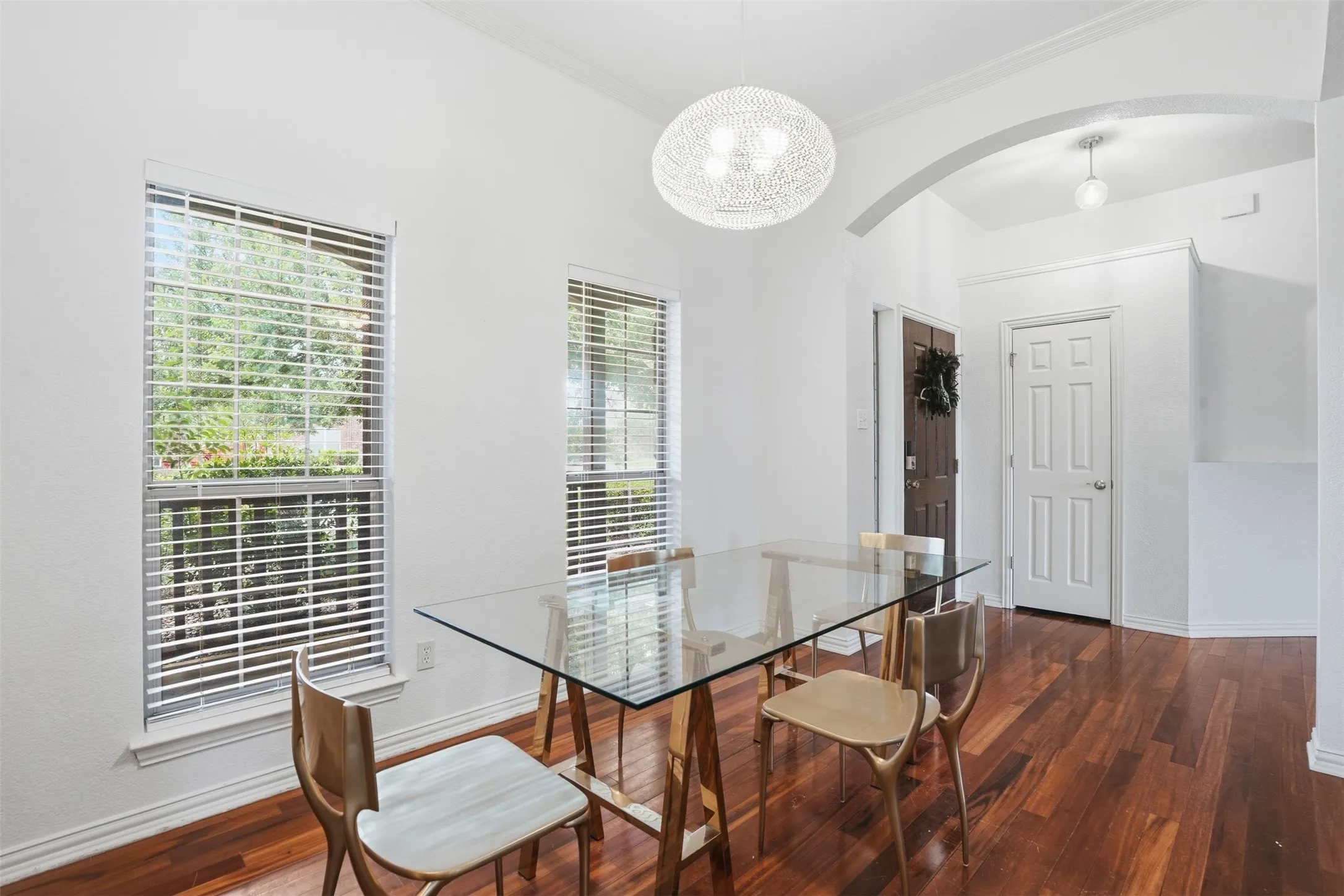 Dining area featuring wood-finish flooring, white walls, and a contemporary pendant light fixture