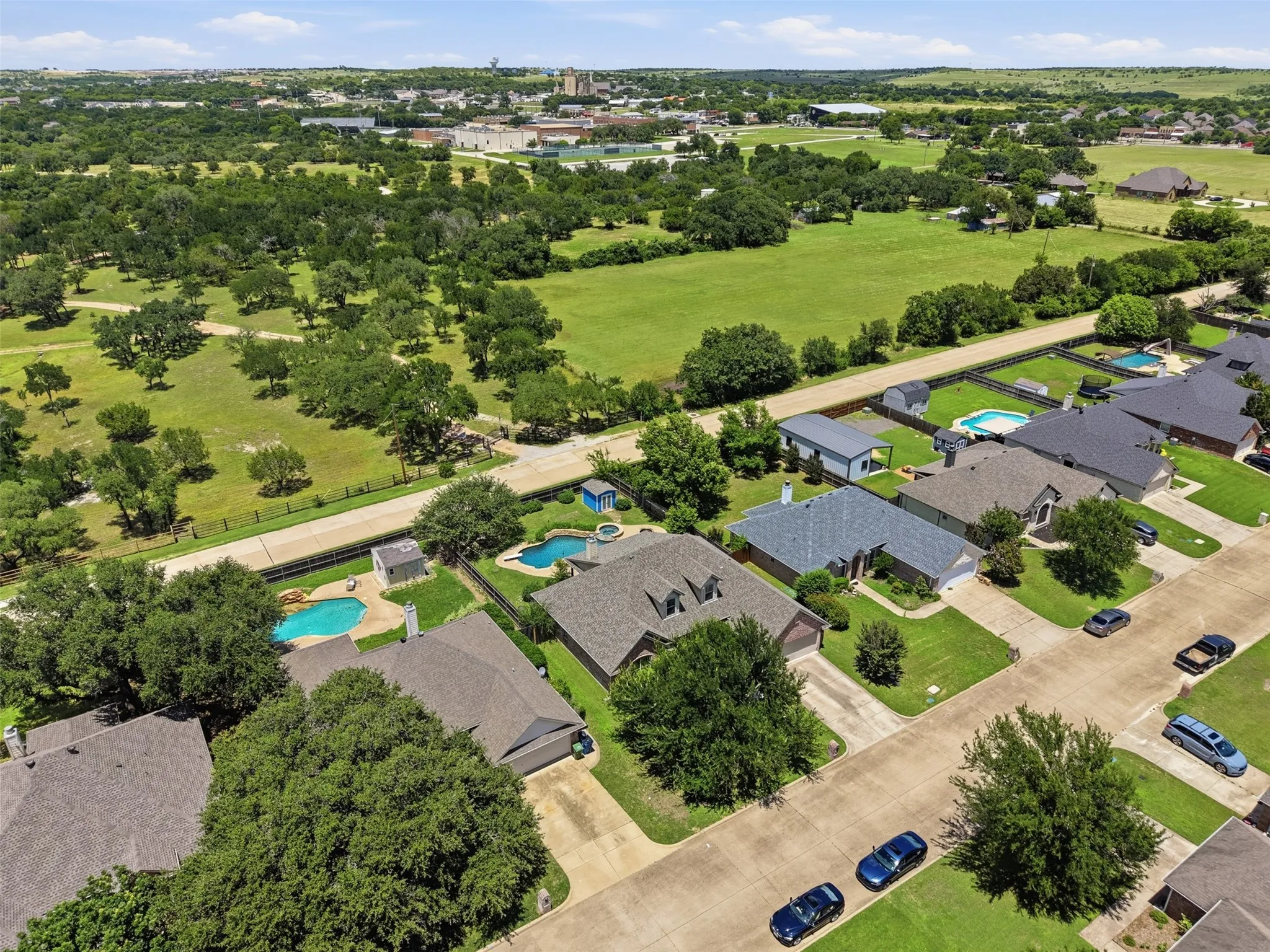 Aerial perspective showcasing residential properties with manicured lawns and mature trees