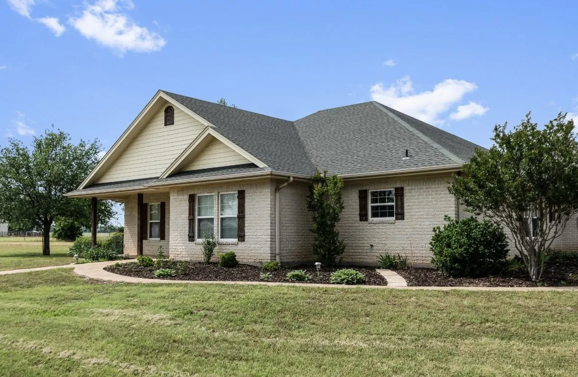 Light brick exterior with gabled roofline and covered porch entry