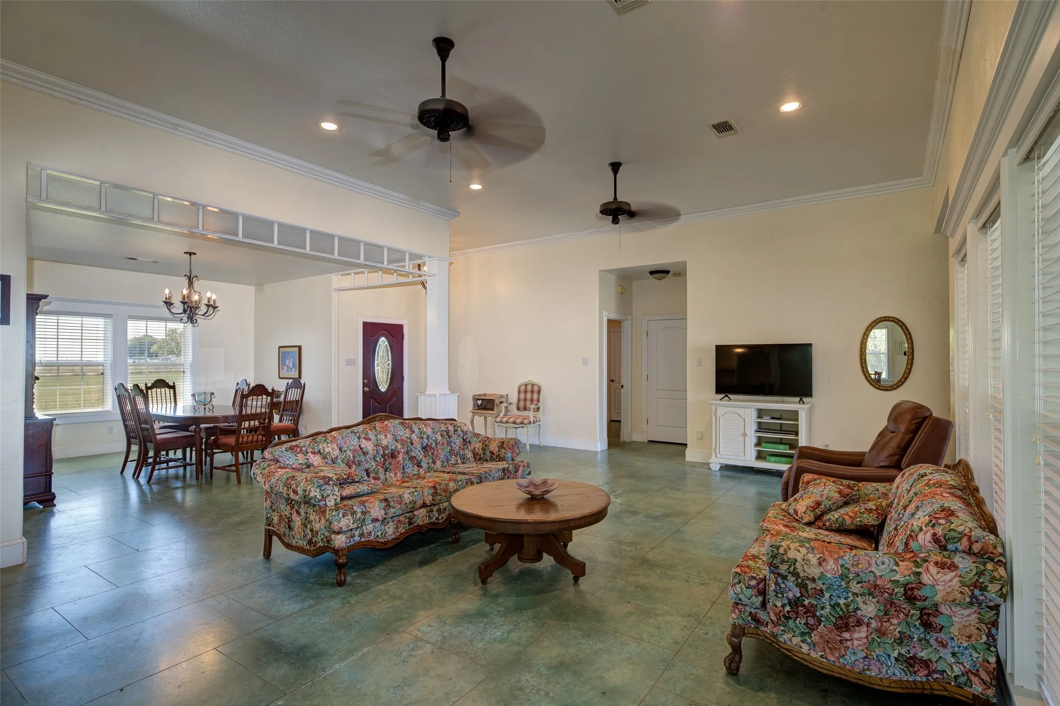 Spacious interior featuring a dining area with chandelier lighting, tall windows, and a semi-open floor plan