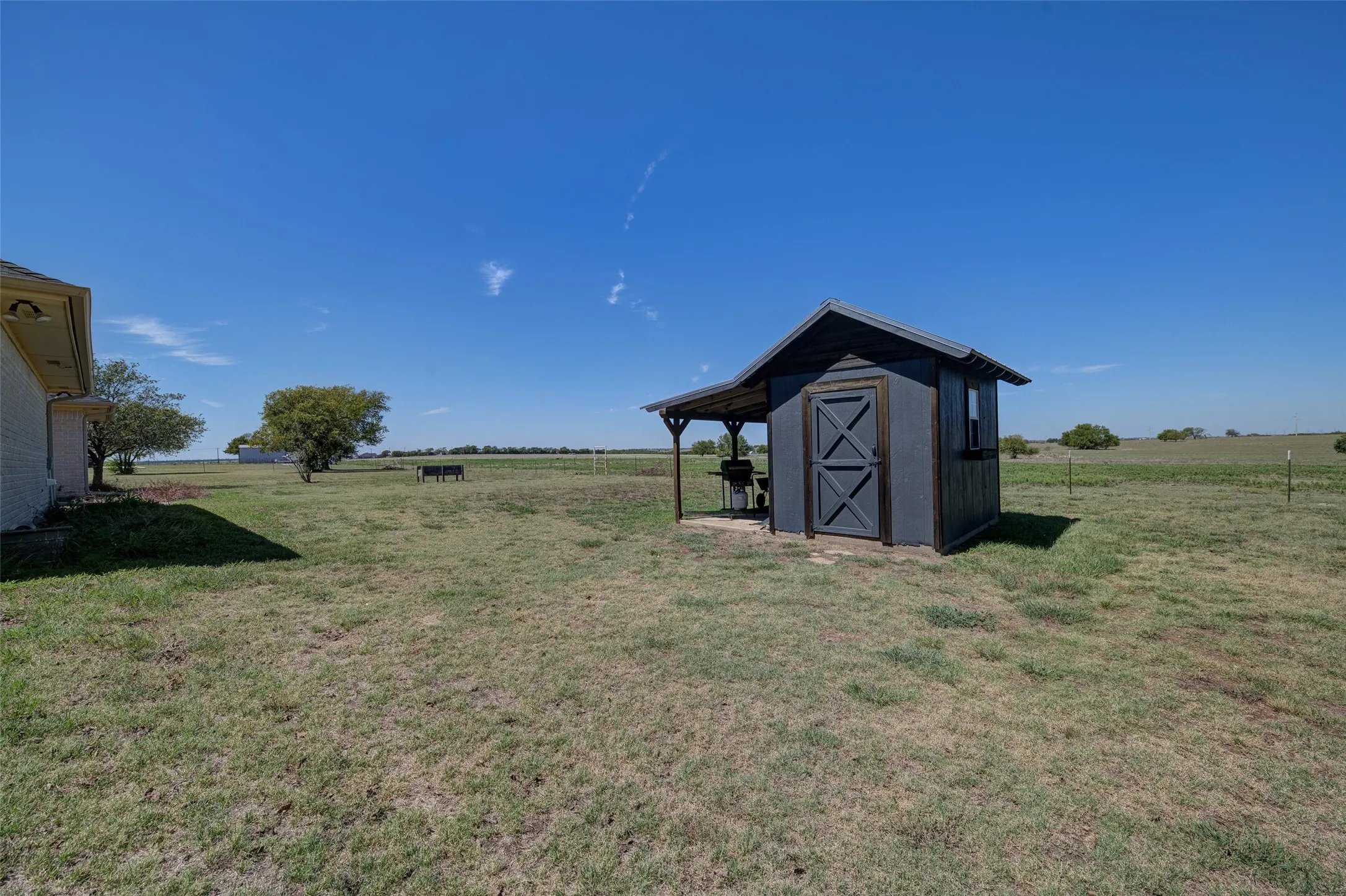 Detached storage shed with a covered outdoor area, barn-style doors, and an exterior window