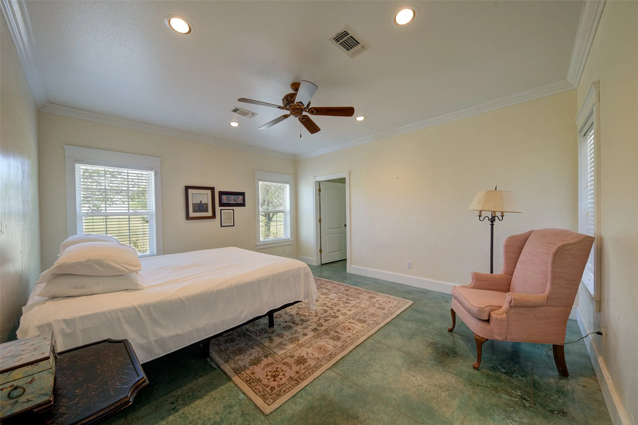 Spacious room featuring light-toned walls, crown molding, and recessed lighting