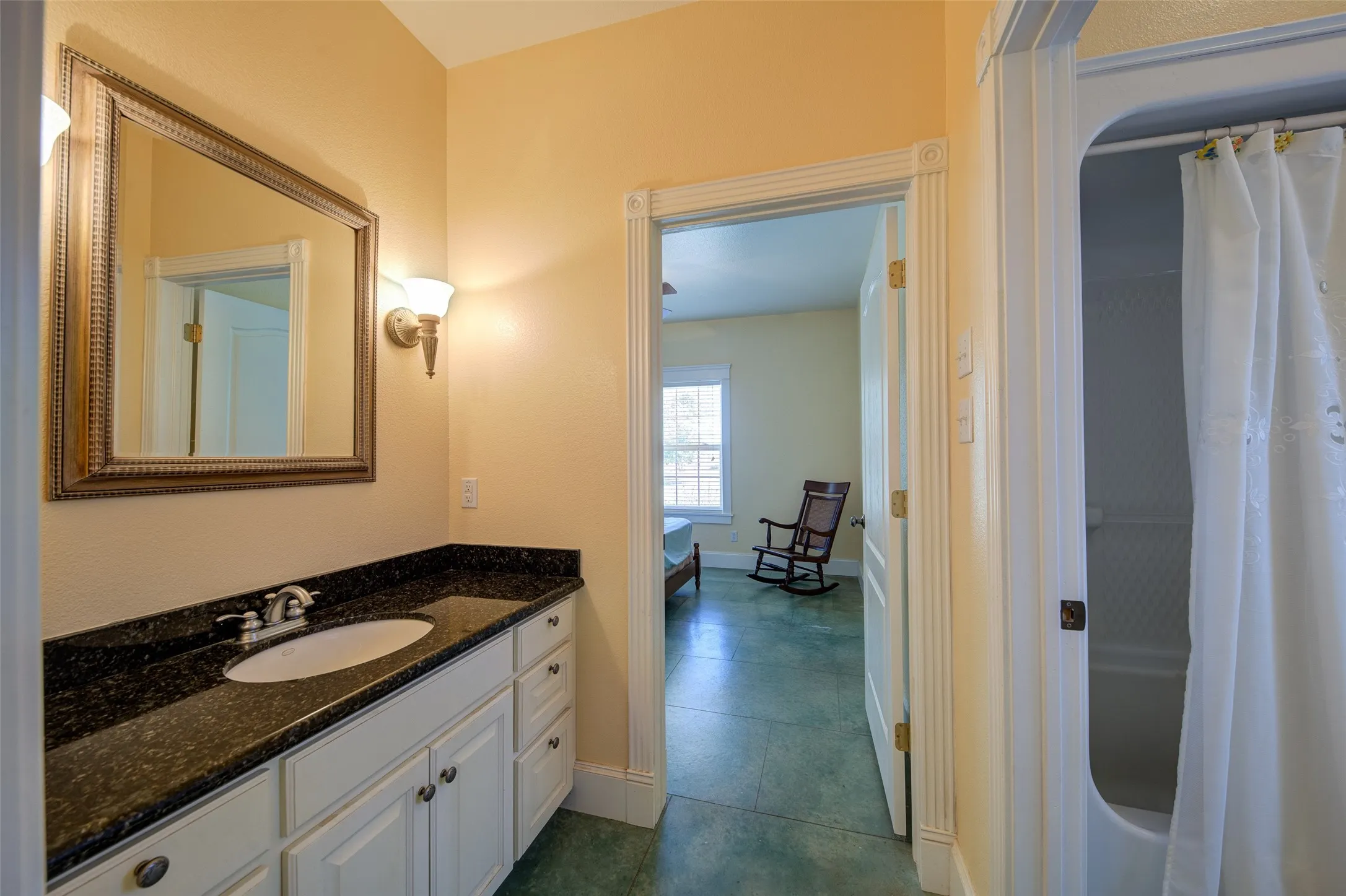 Vanity featuring a dark speckled countertop, undermount sink, and brushed nickel faucet