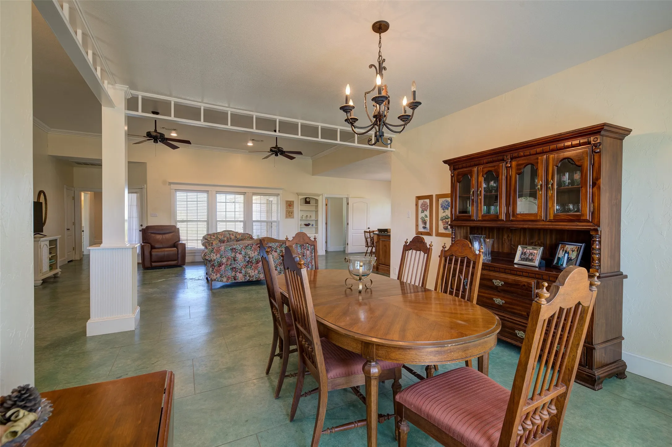 Dining area featuring a classic chandelier and durable green-hued flooring