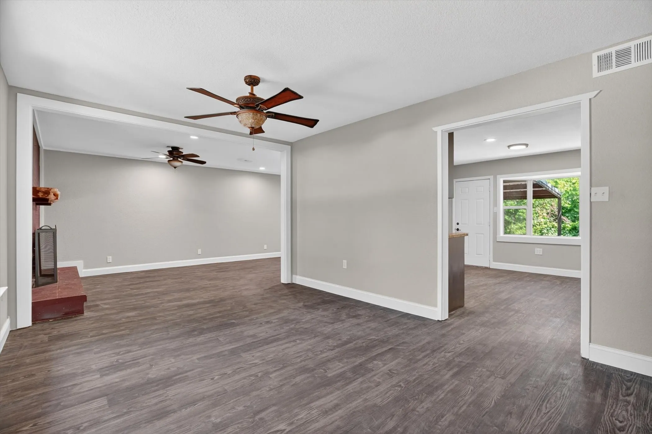 Open concept living spaces featuring wood-finish flooring, light gray walls, and white trim