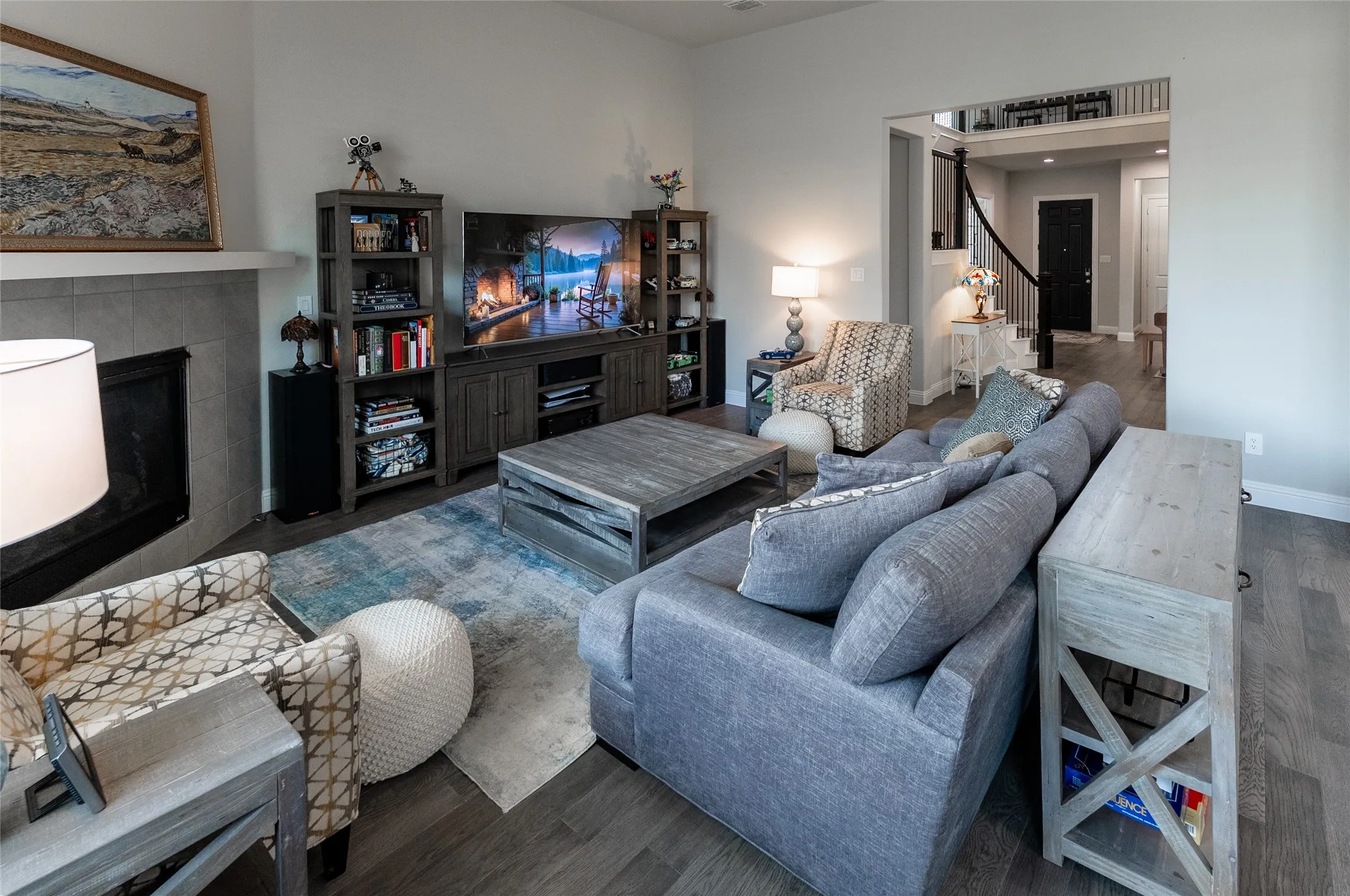 Living room with ceiling fan and fireplace. Front door in background.