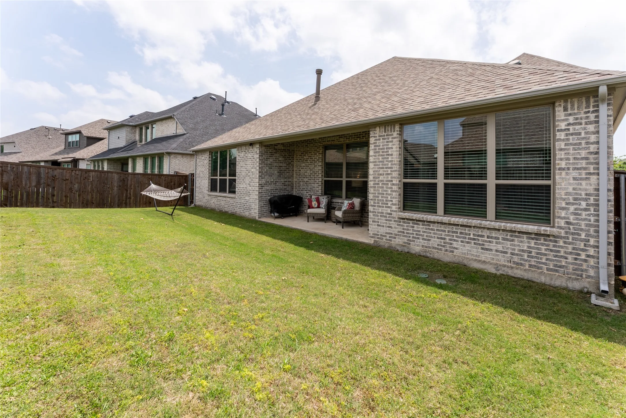 Backyard featuring grass and covered back patio.