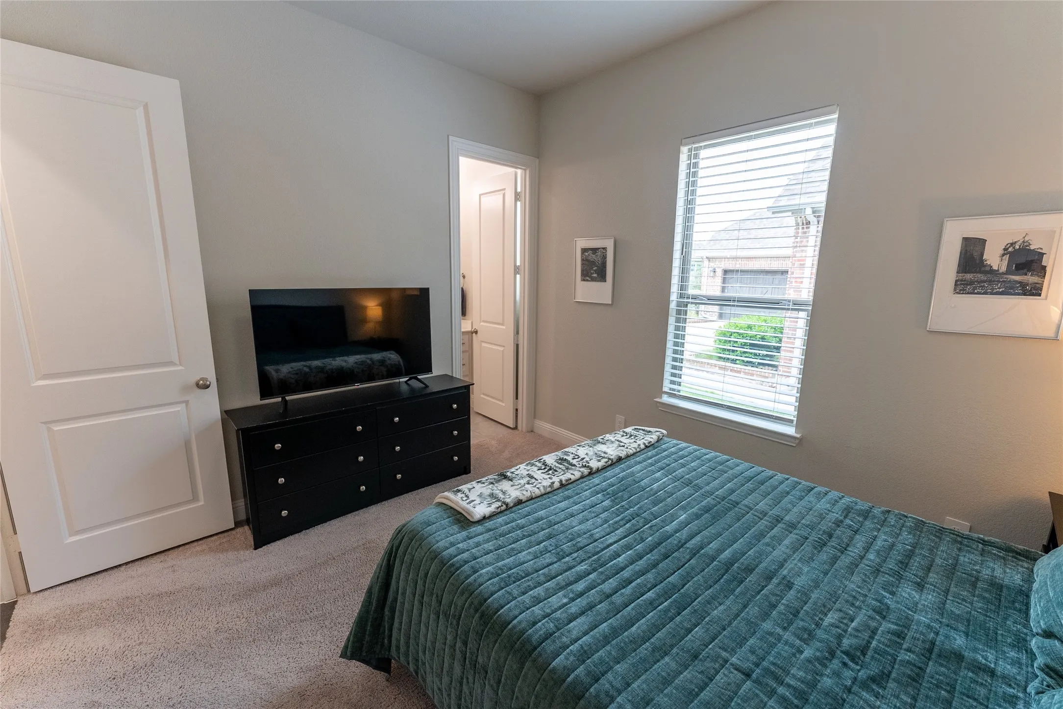 Bedroom 2 featuring an en suite bathroom, closet and carpet downstairs.