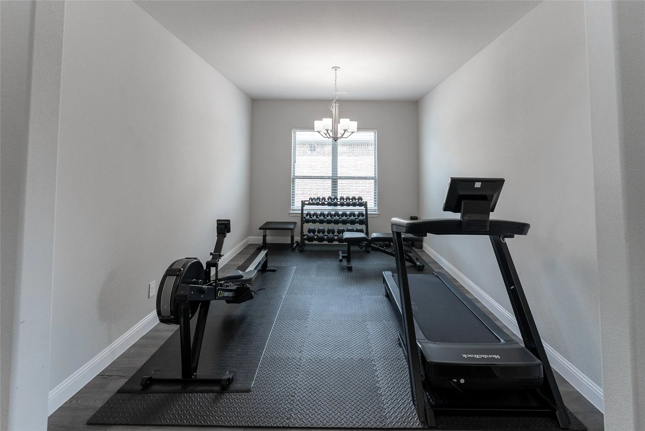 Formal dining room featuring a chandelier and plenty of natural light. Currently being used as an exercise room.
