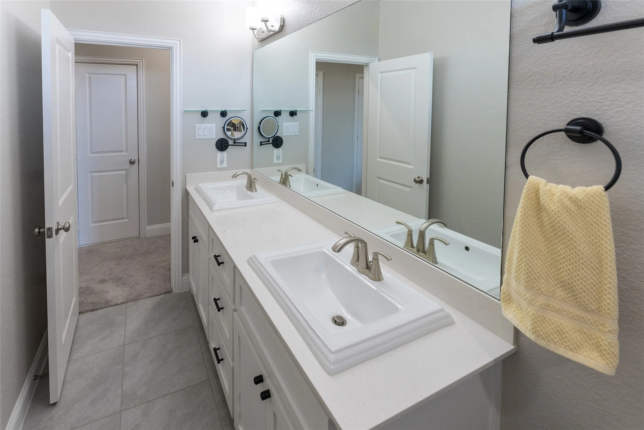 Upstairs bathroom featuring tile flooring and double vanities.
