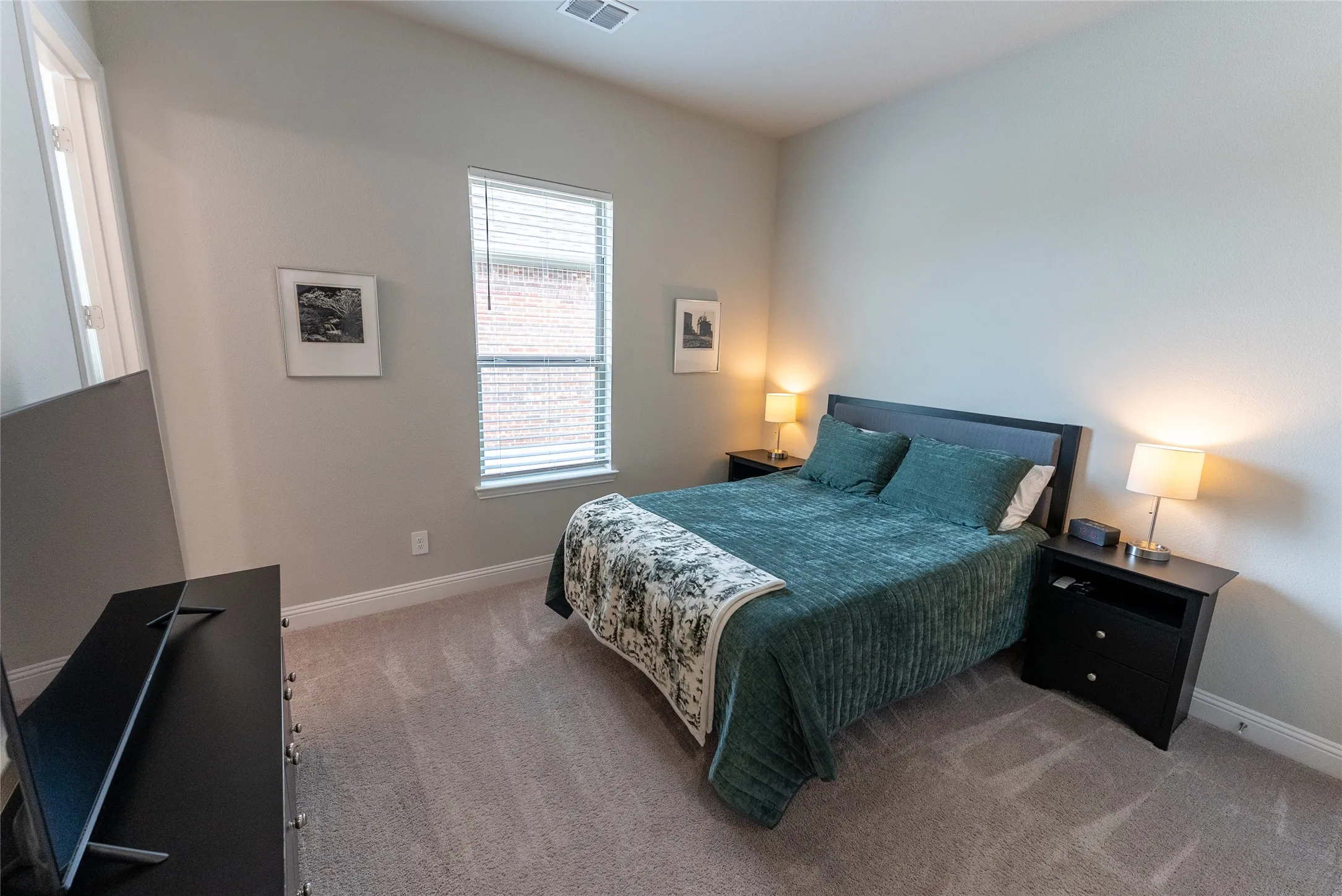 Bedroom 2 featuring an en suite bathroom, closet and carpet downstairs.