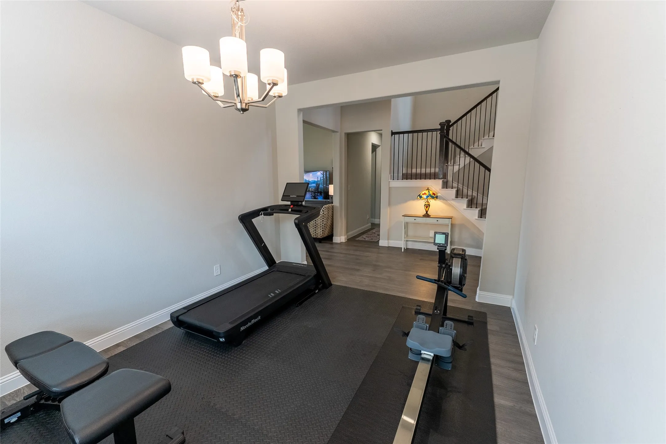 Formal dining room featuring a chandelier and plenty of natural light. Currently being used as an exercise room.