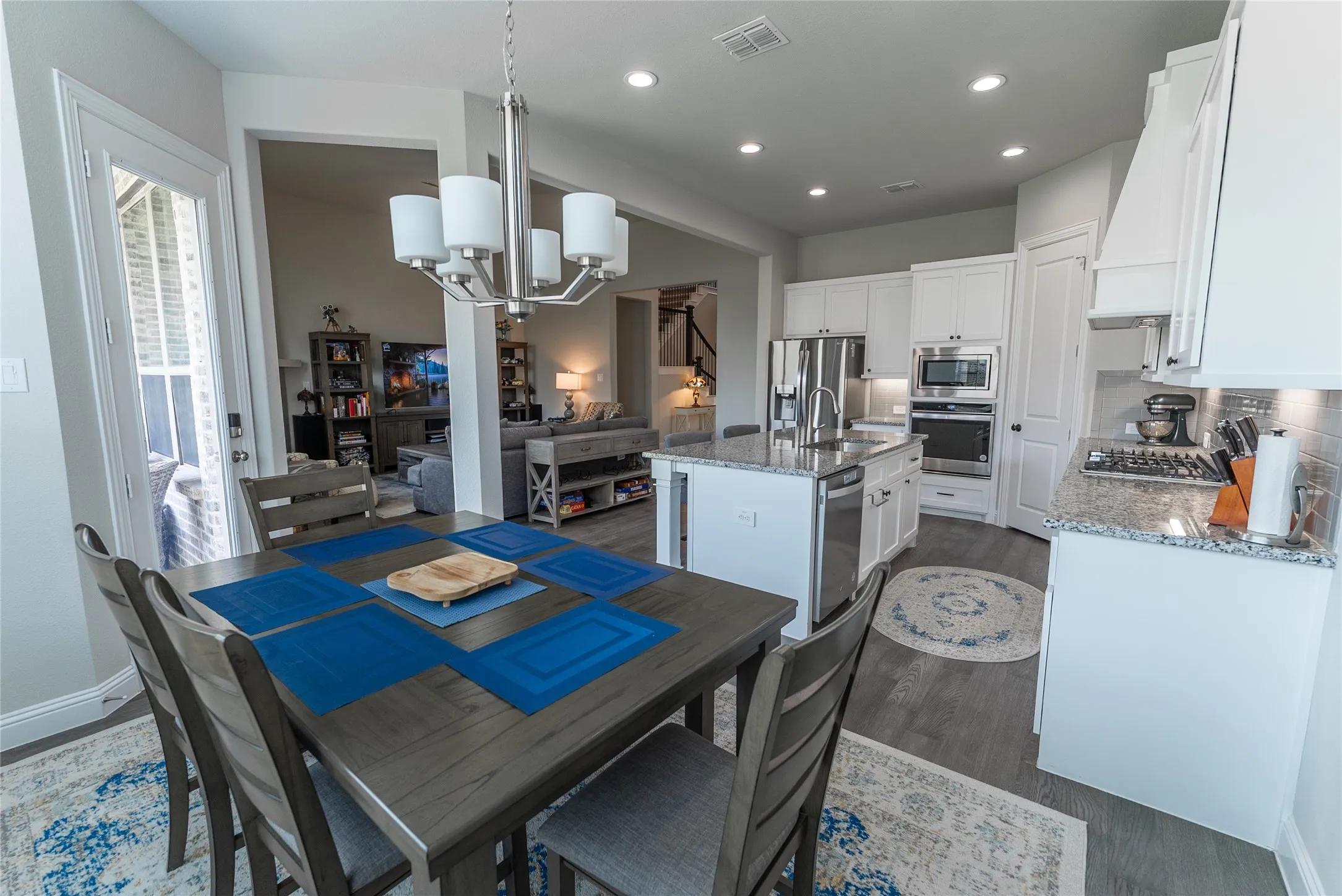 Eat in kitchen with chandelier and LVP flooring.