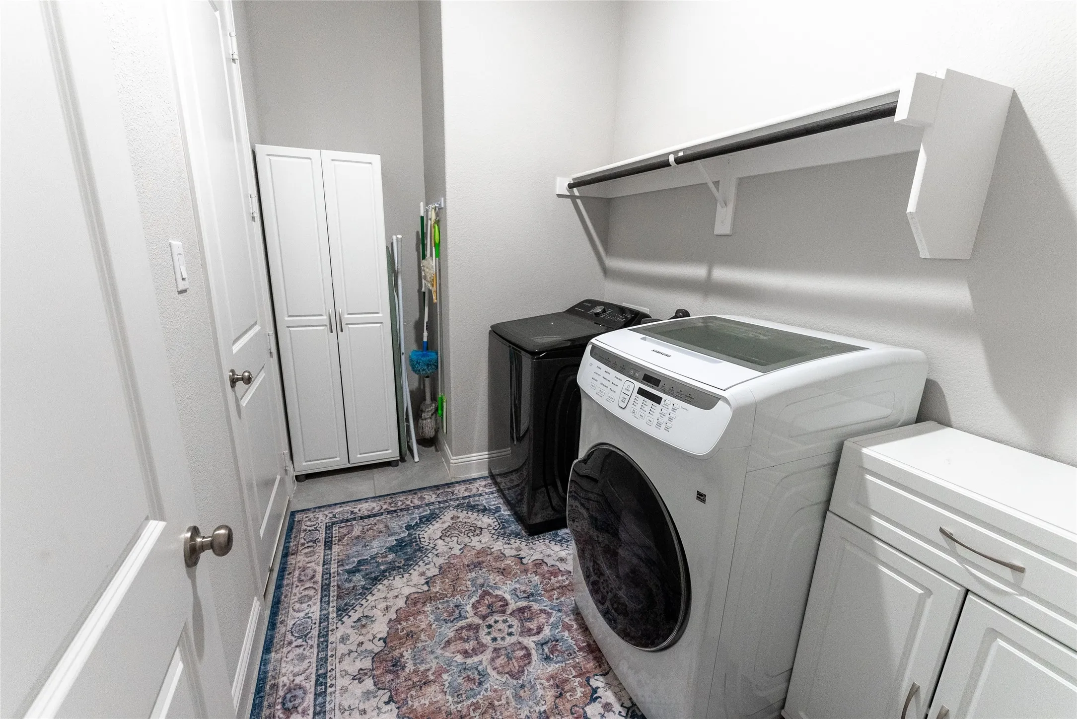 Laundry room with shelving and door that leads to 1 out of the 3 garages.
