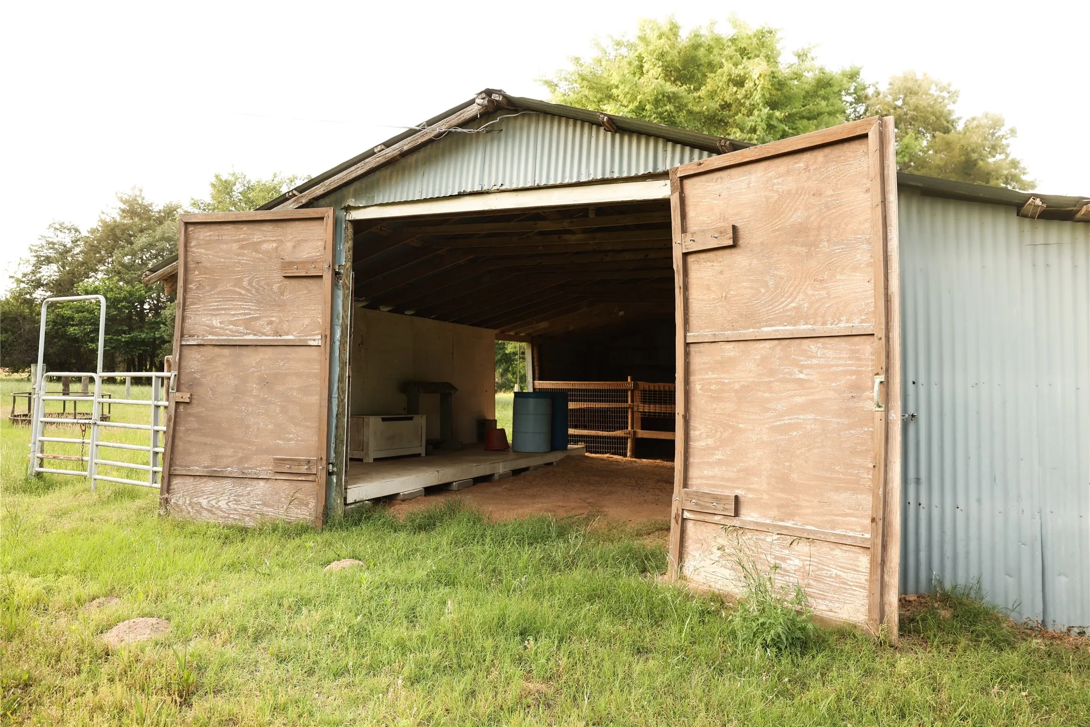 Barn has four stalls and wood tack and feed area
