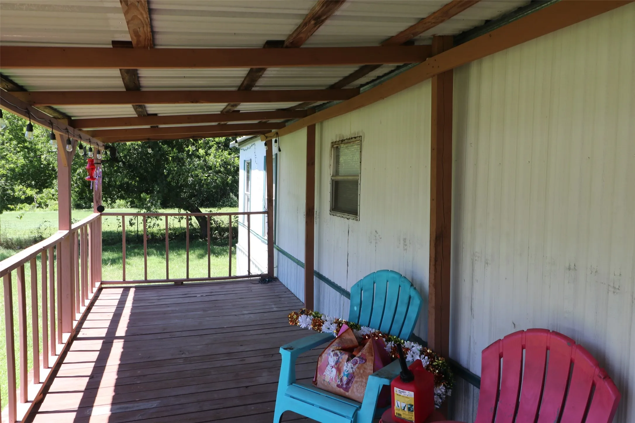 Covered porch featuring wood-finish decking and perimeter railing