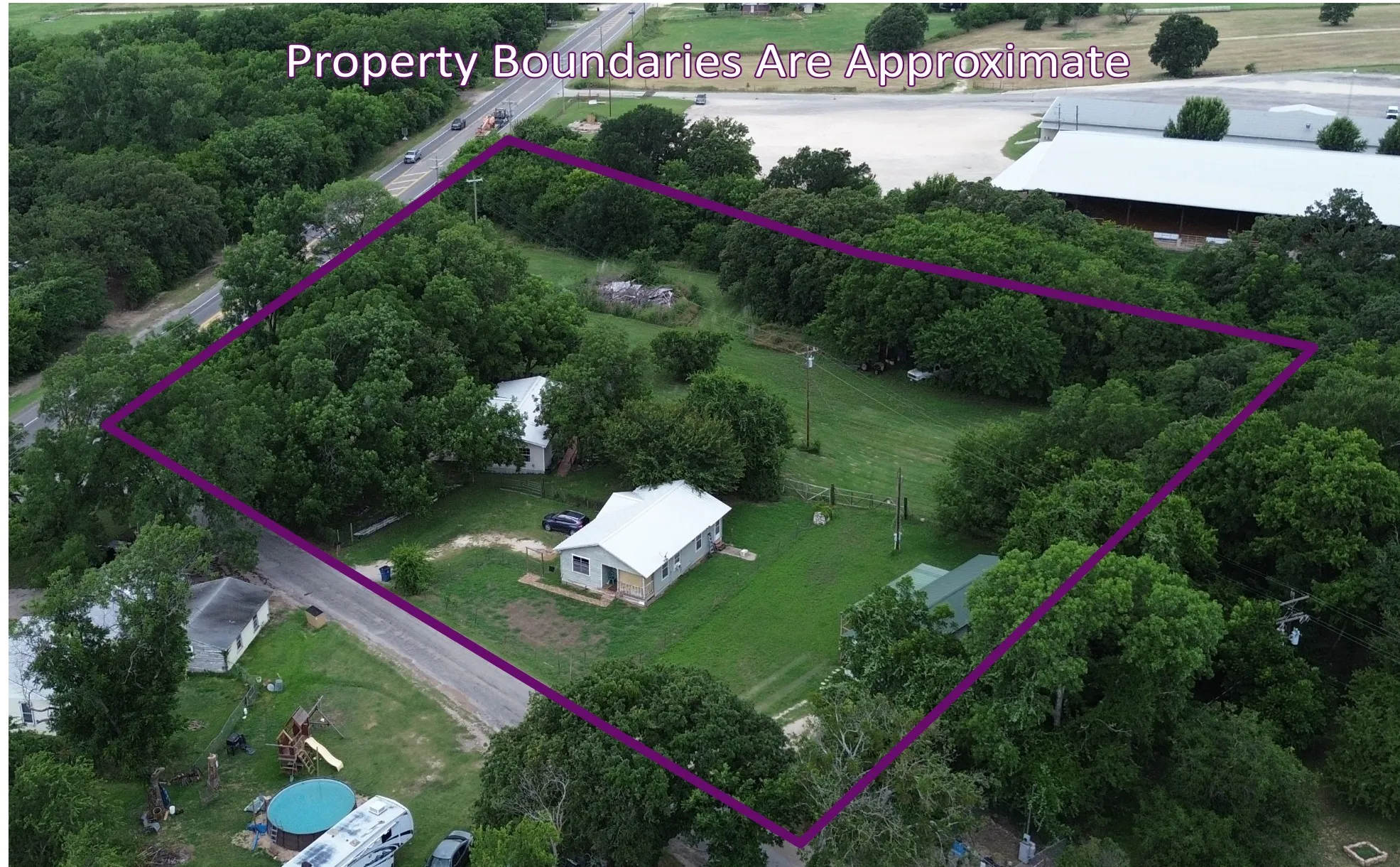 Spacious lot featuring a main residence and multiple outbuildings, surrounded by mature trees