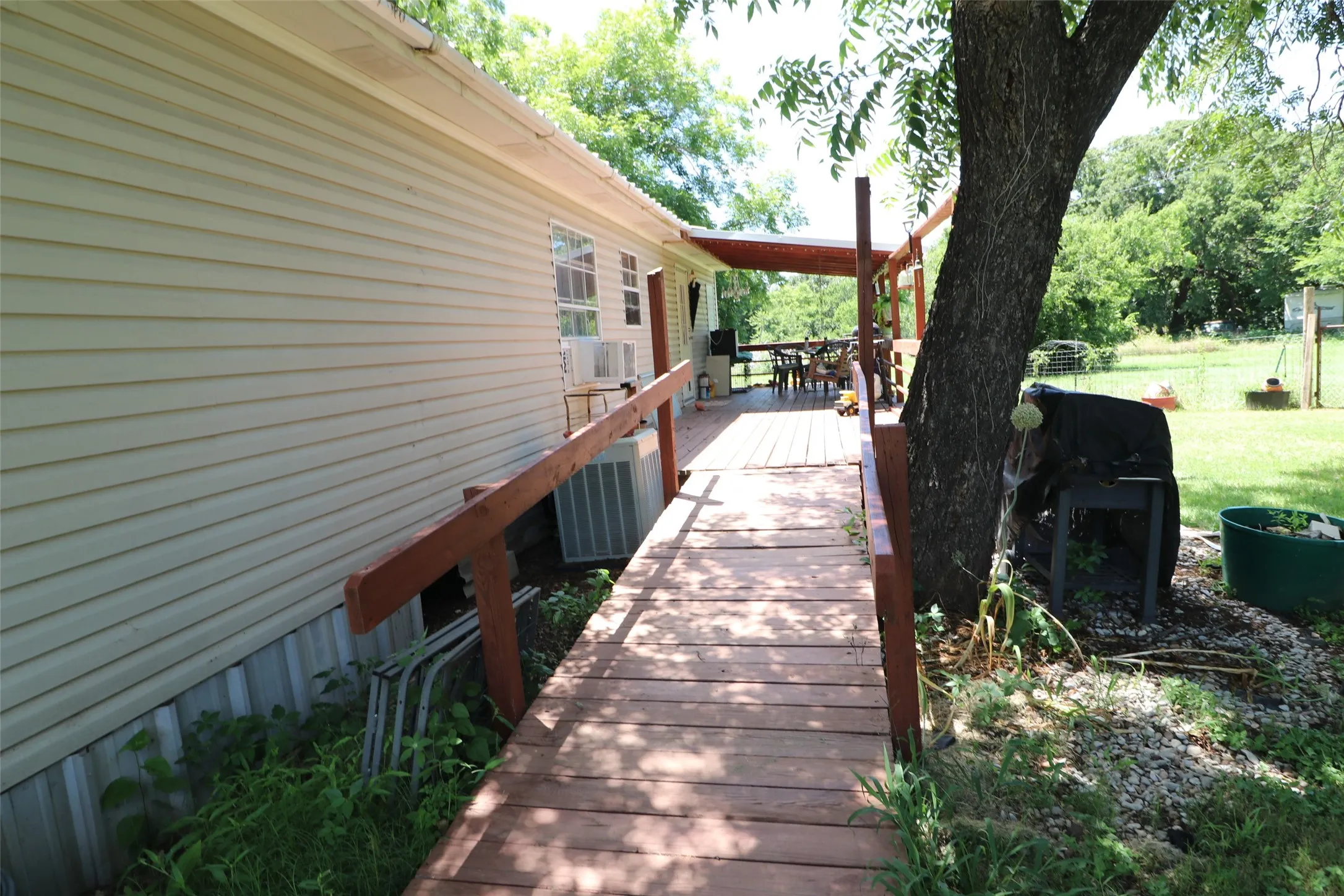 Expansive wood-finish deck with a covered outdoor area