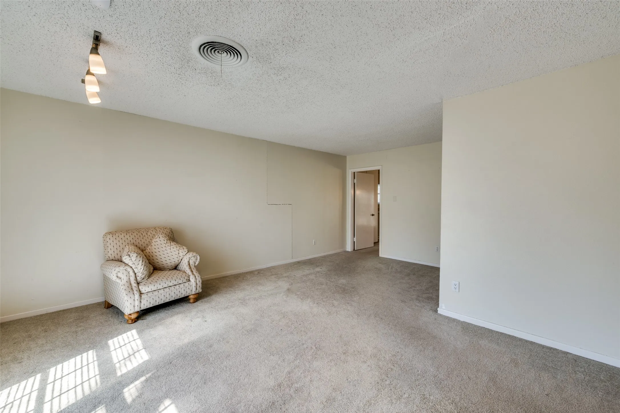 Carpeted interior space featuring light-toned walls