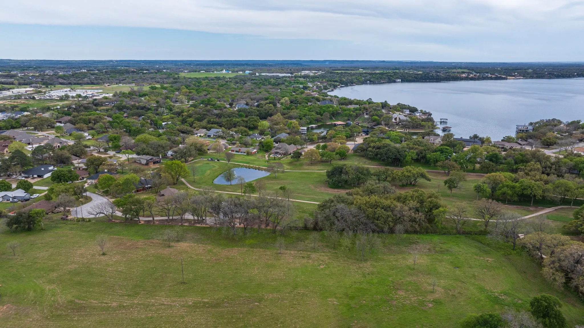 Expansive green landscape with scattered trees, and boarders established DeCordova Bend Estates Country Club.