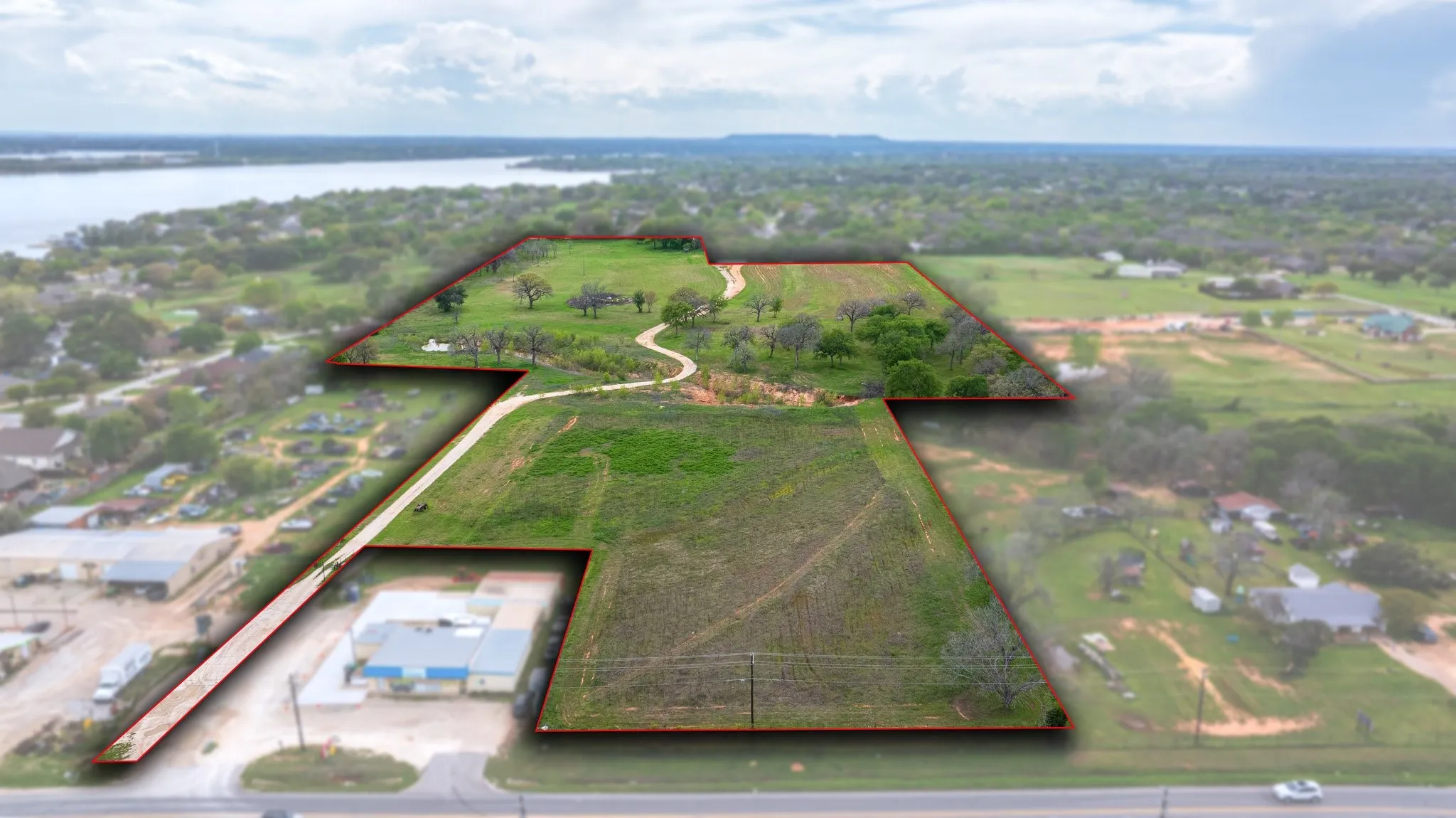 Expansive land parcel featuring varied terrain including open fields and areas with mature trees
