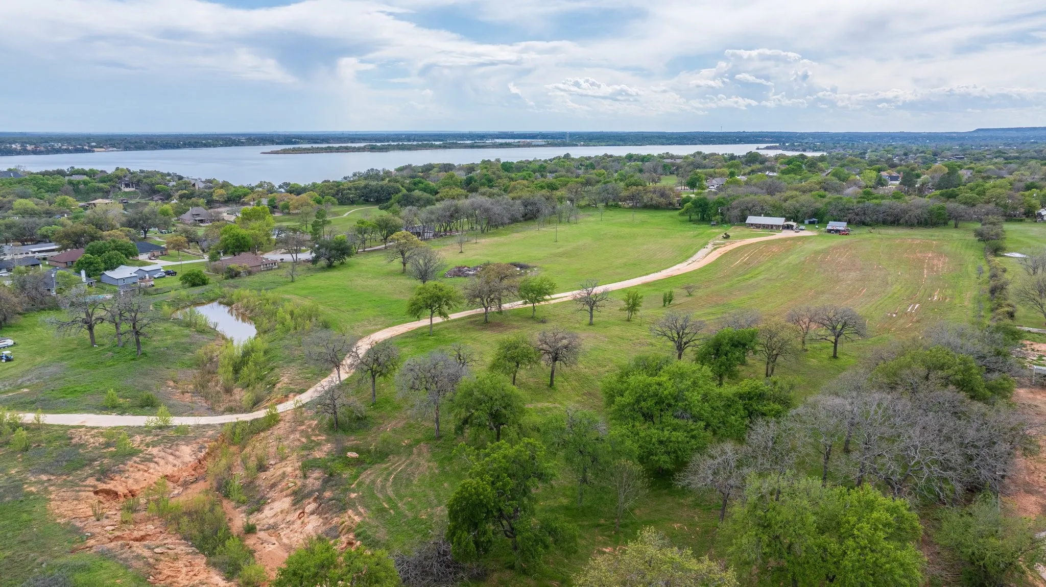 Expansive green landscape with mature trees and a winding dirt path