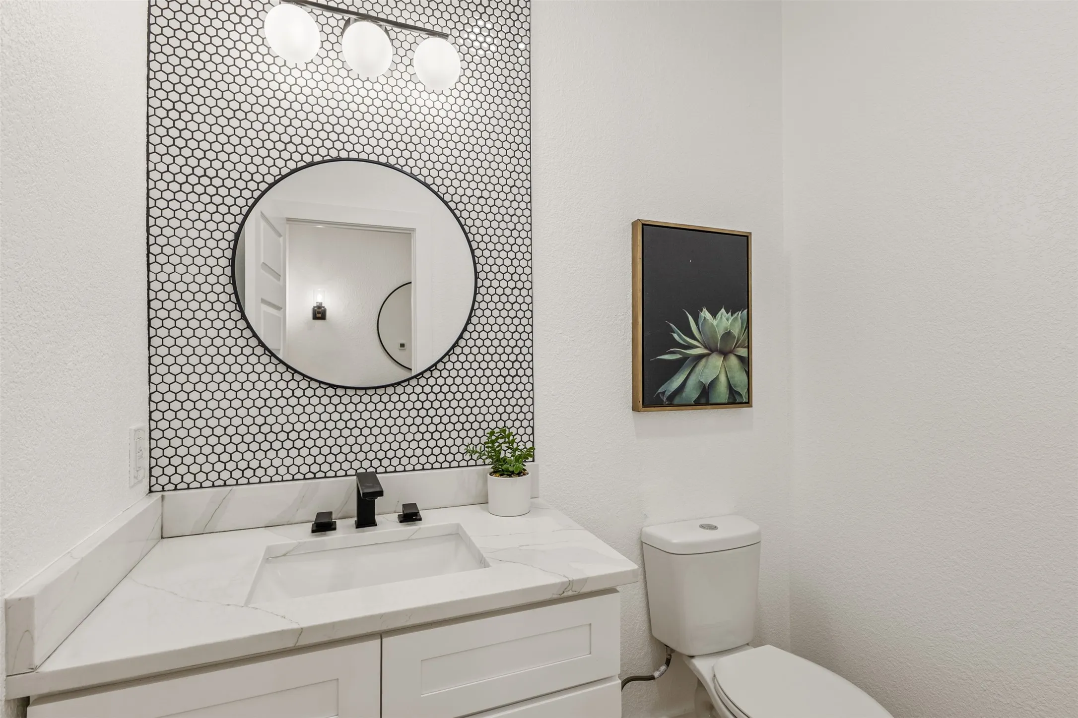 Half bath featuring vanity and a textured wall