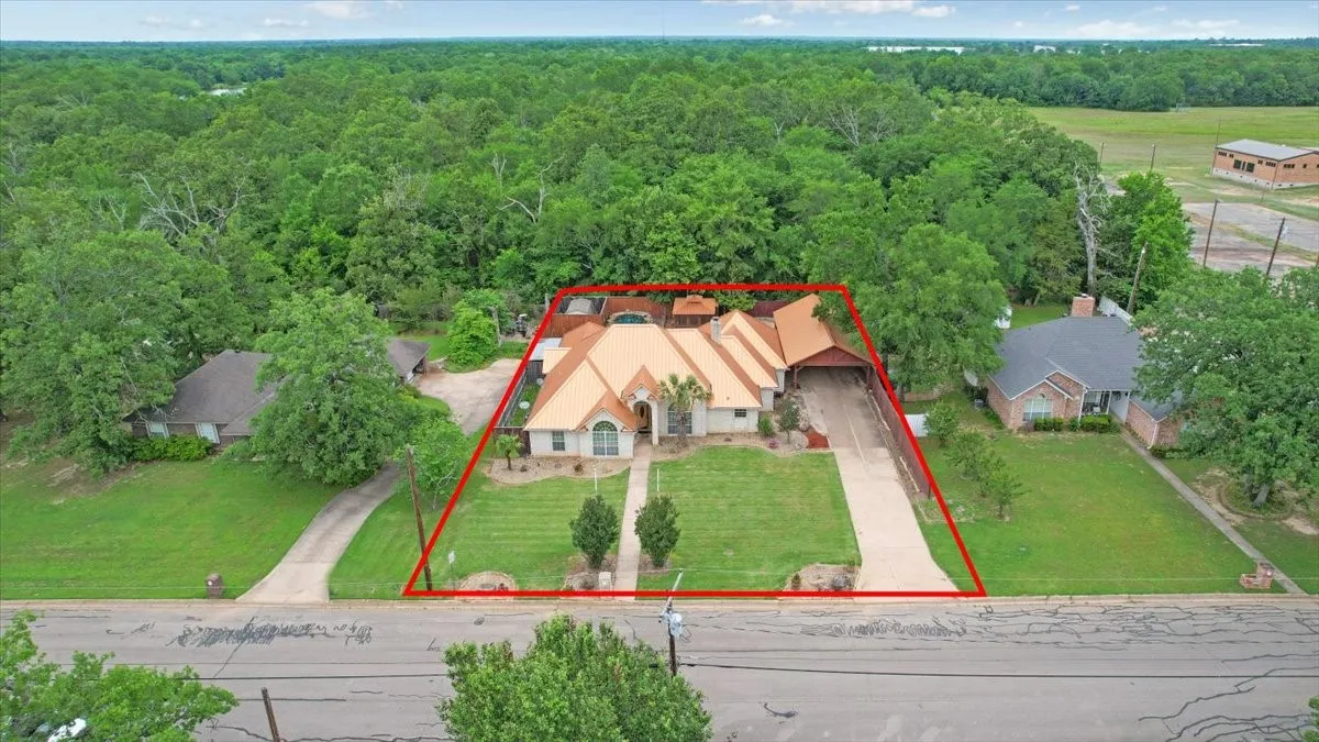 Single-story residence featuring a distinctive orange-toned roof, an arched entry, and a covered driveway