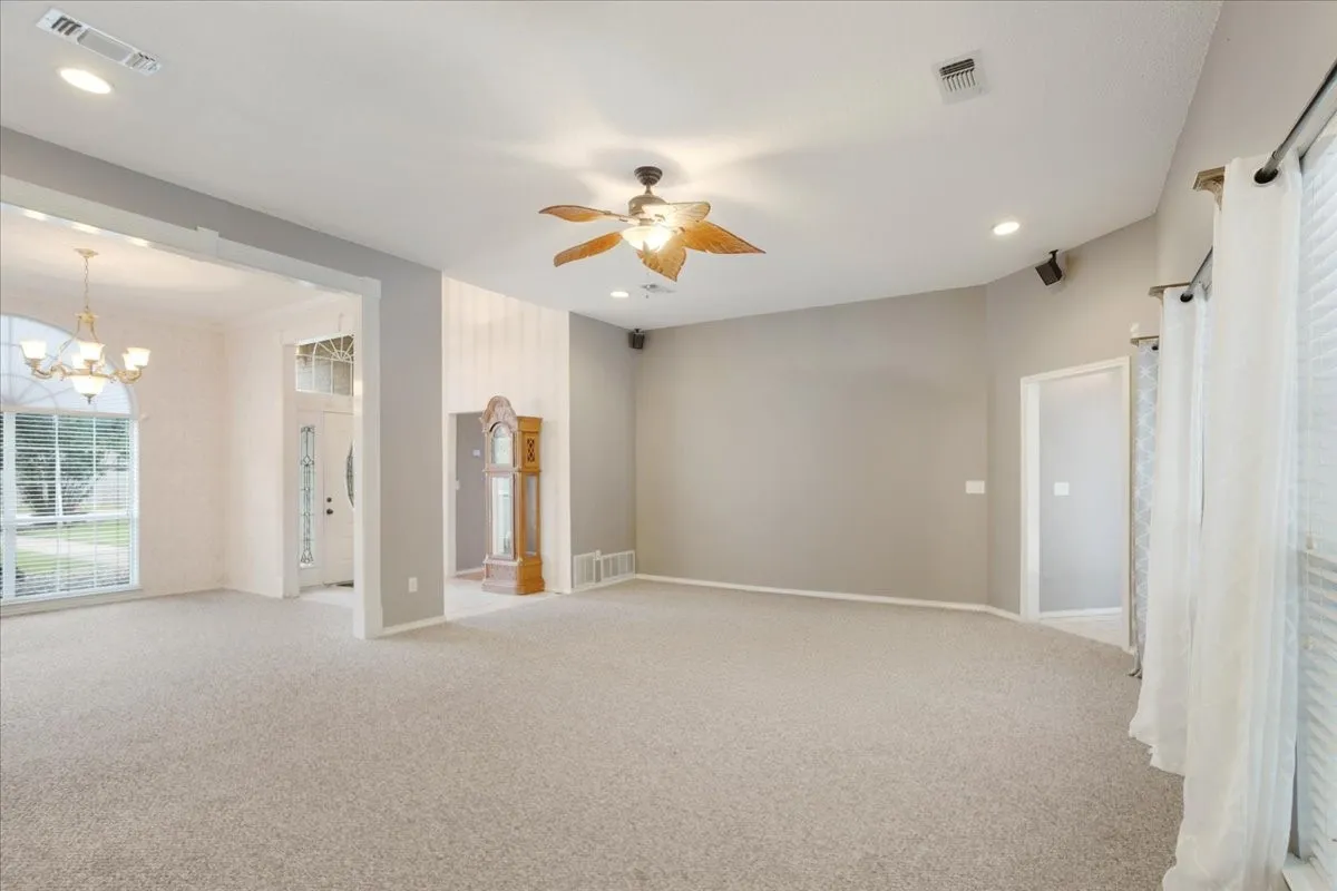 Spacious living area featuring recessed lighting, and a ceiling fan.