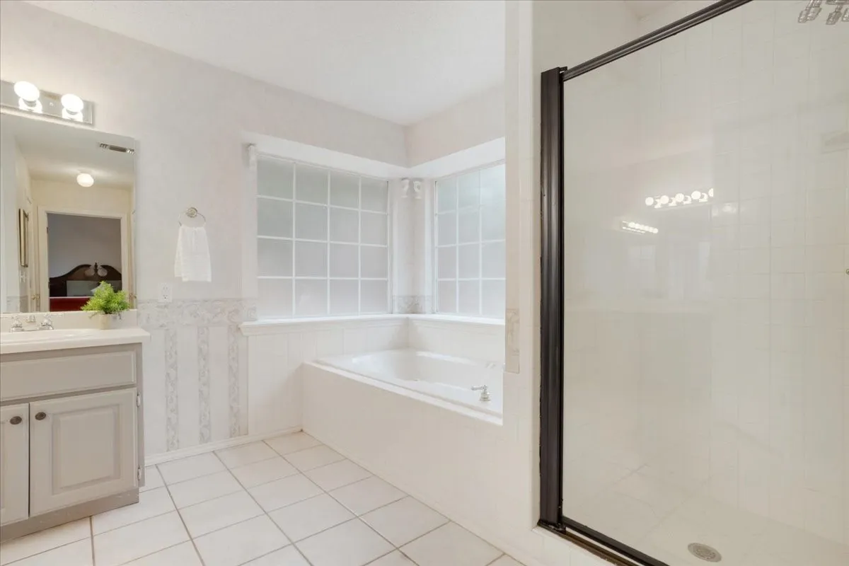 Bathroom featuring a built-in soaking tub, a separate glass-enclosed shower.