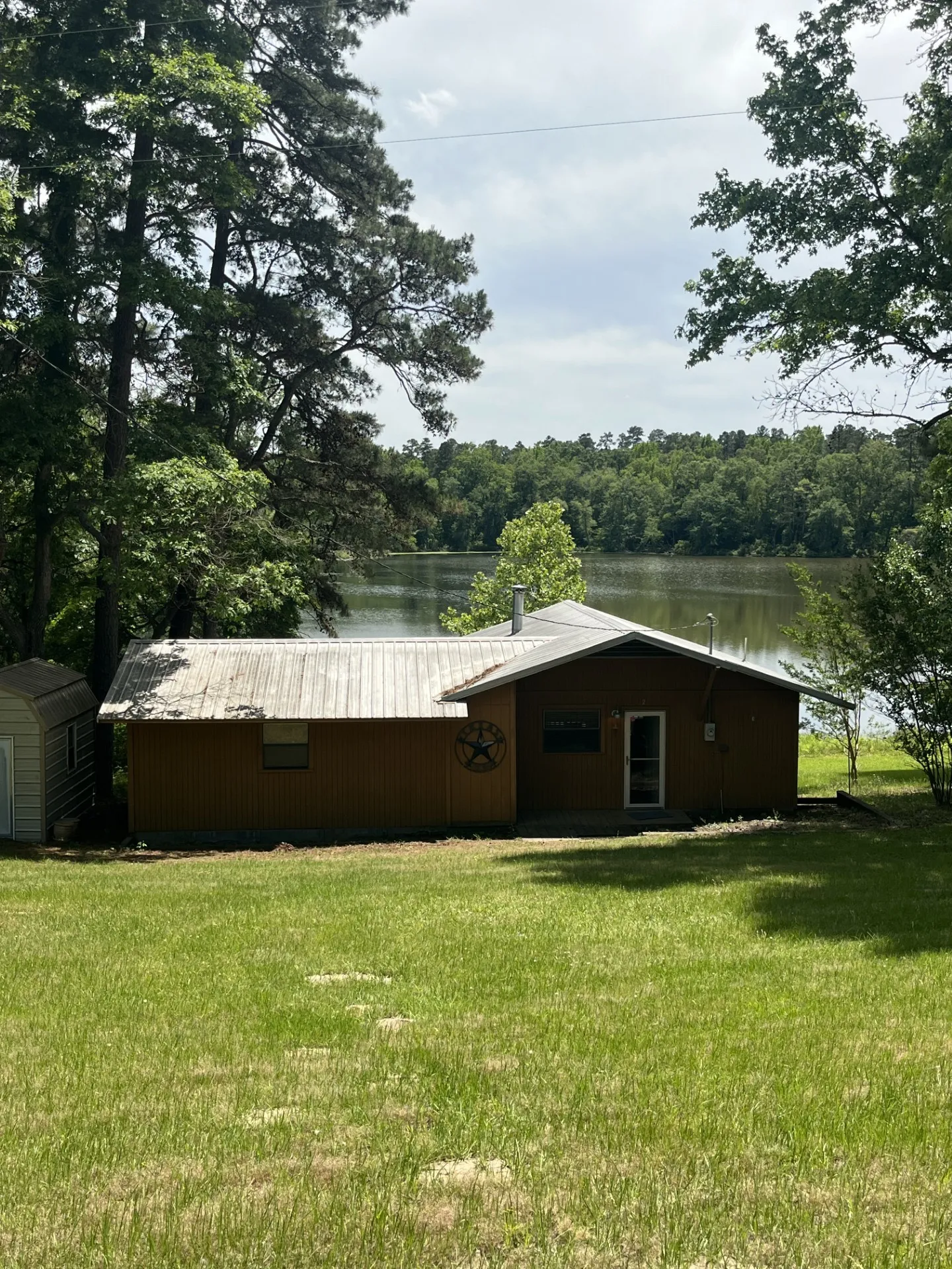 Lakefront property featuring a metal roof and a spacious green lawn