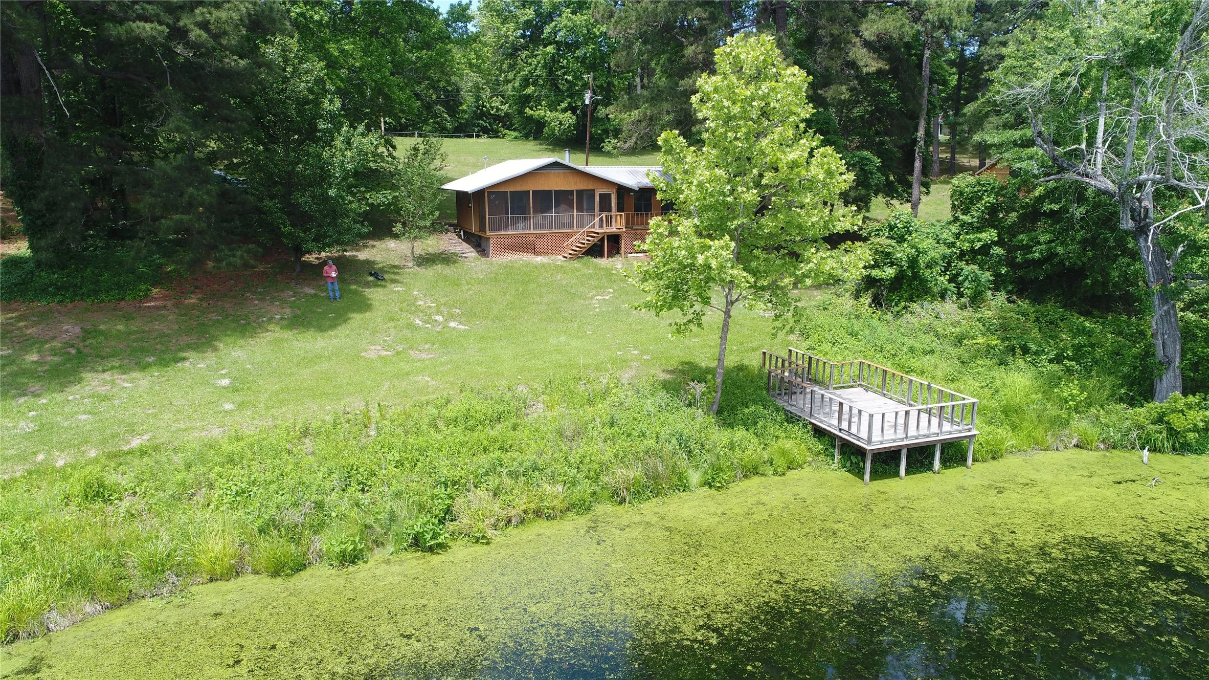 Wood-sided cabin featuring a screened porch and a metal roof