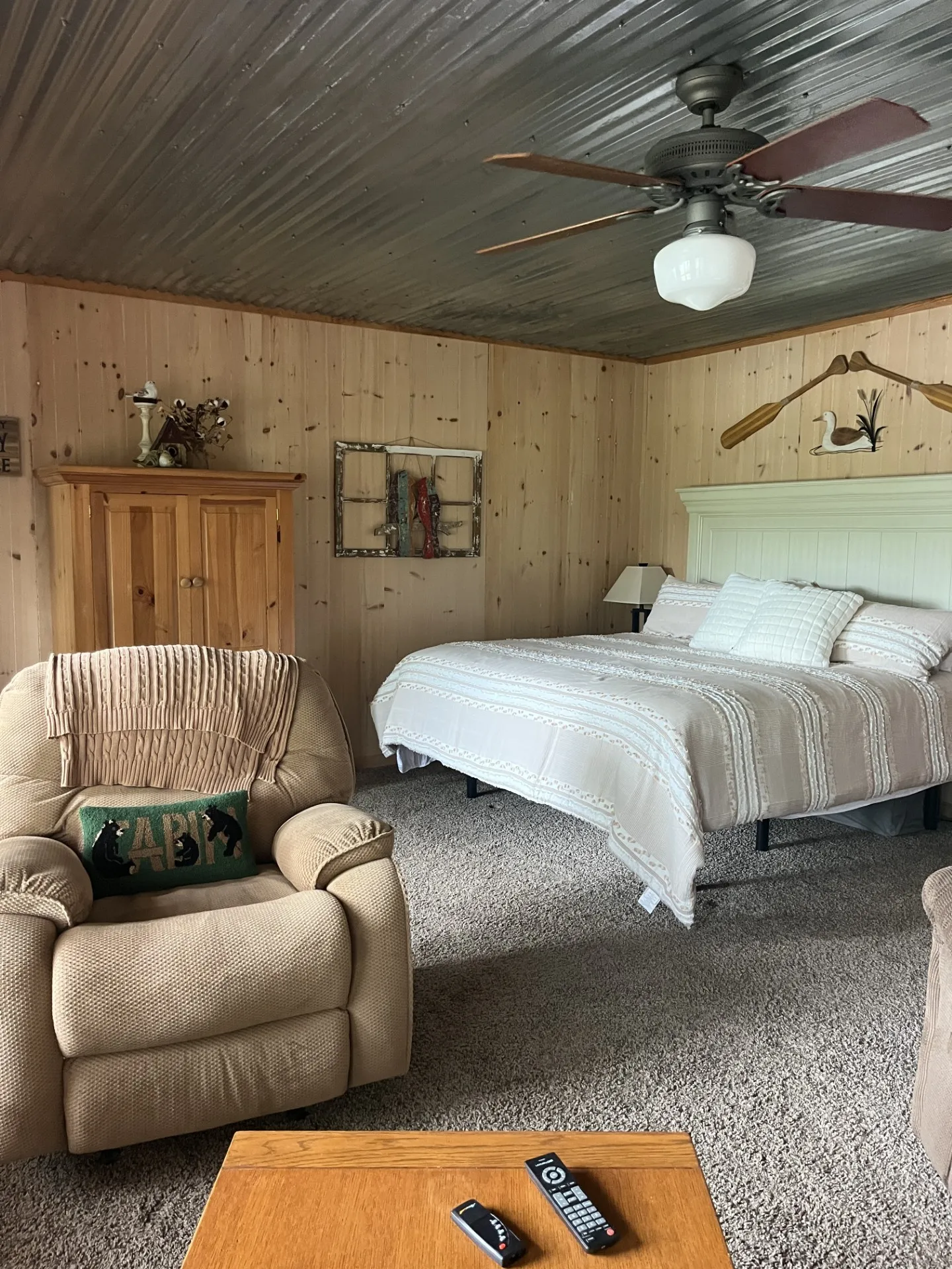 Room featuring wood paneling, corrugated metal ceiling, and soft carpet flooring