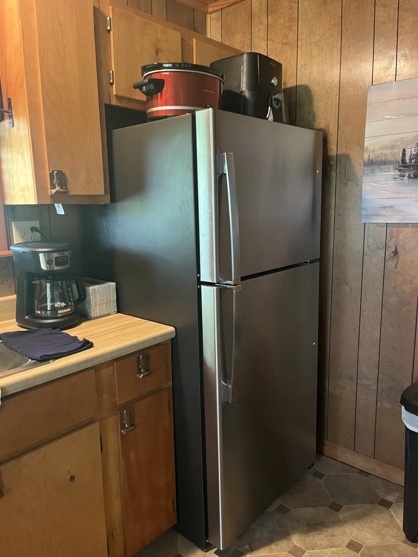 Stainless steel refrigerator and overhead wood cabinetry