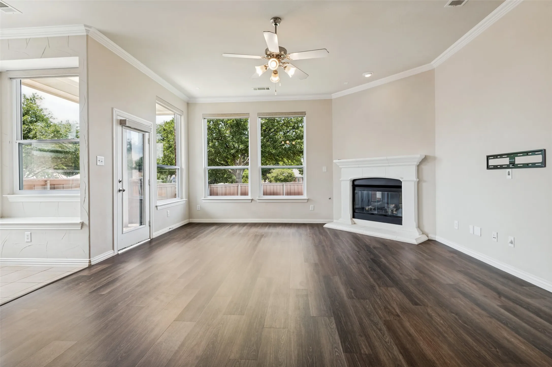 Spacious living area with a traditional fireplace. Beautiful white fireplace mantel and hearth.  Extensive natural light from multiple windows featuring remote control blinds.